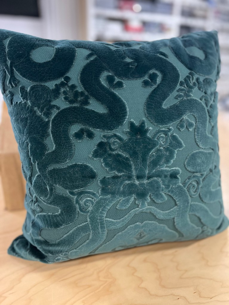 Custom made throw pillow in a teal designer cut velvet fabric with snakes intertwining in the middle around a medallion.