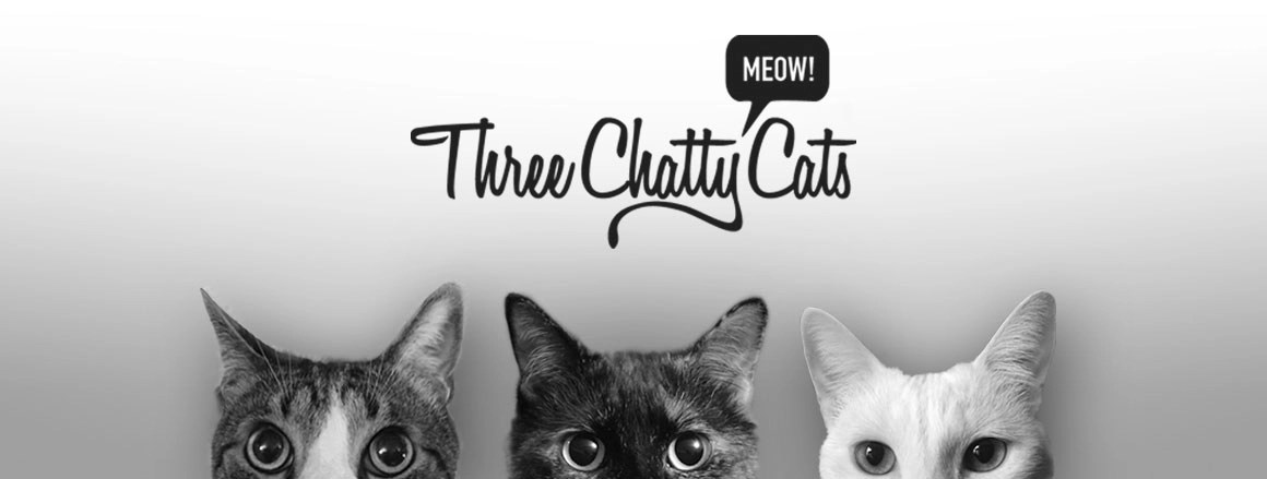 three cats peeking up from bottom of image in black and white