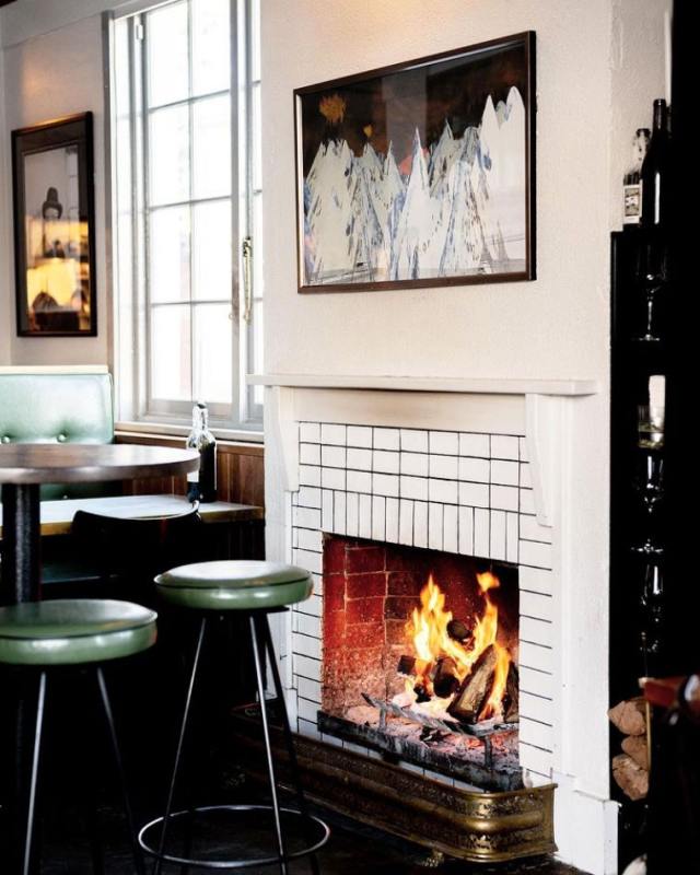 A fireplace with stools and stools in a room with a window

Description automatically generated with low confidence