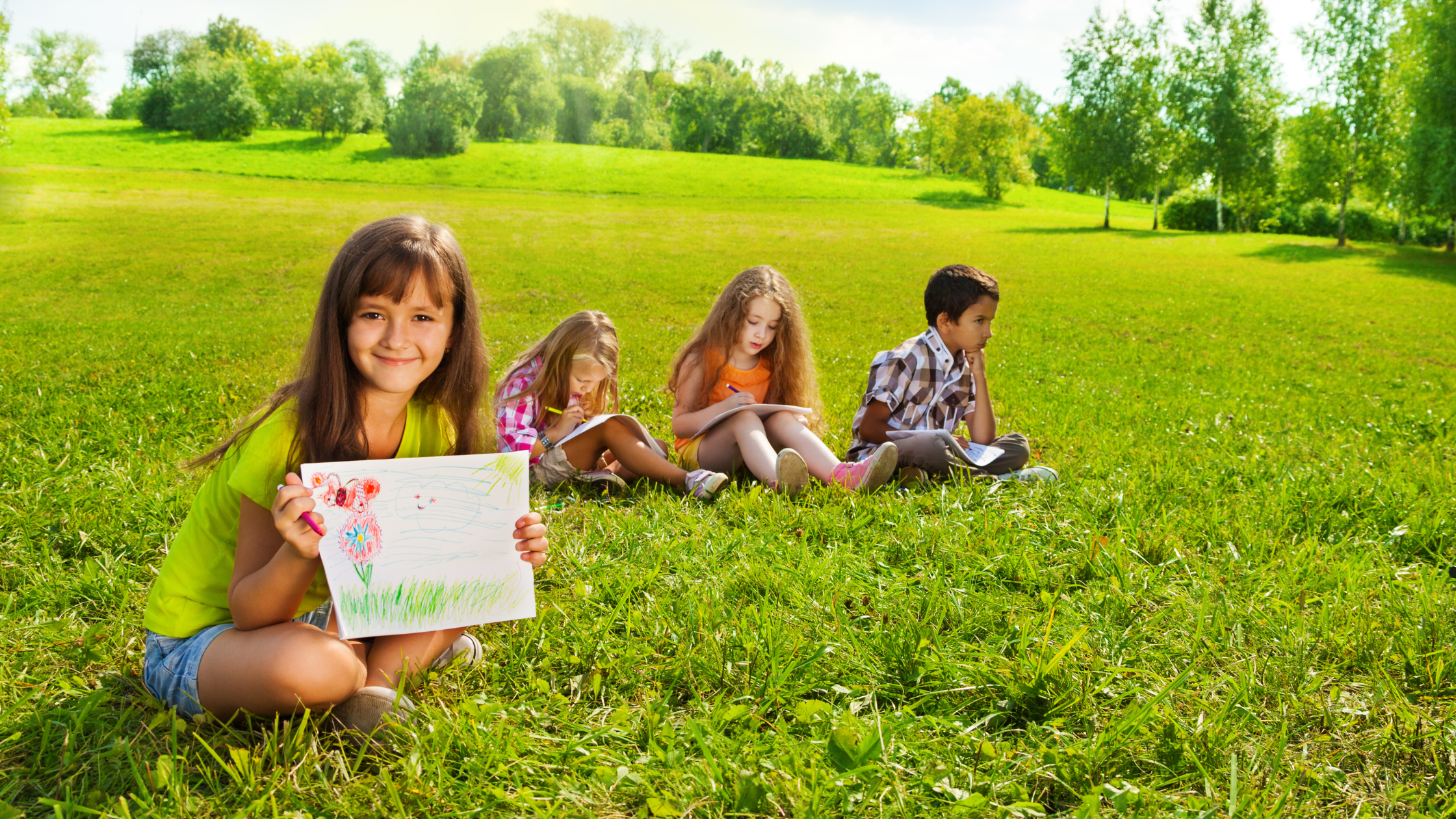 4 kids drawing pictures outside