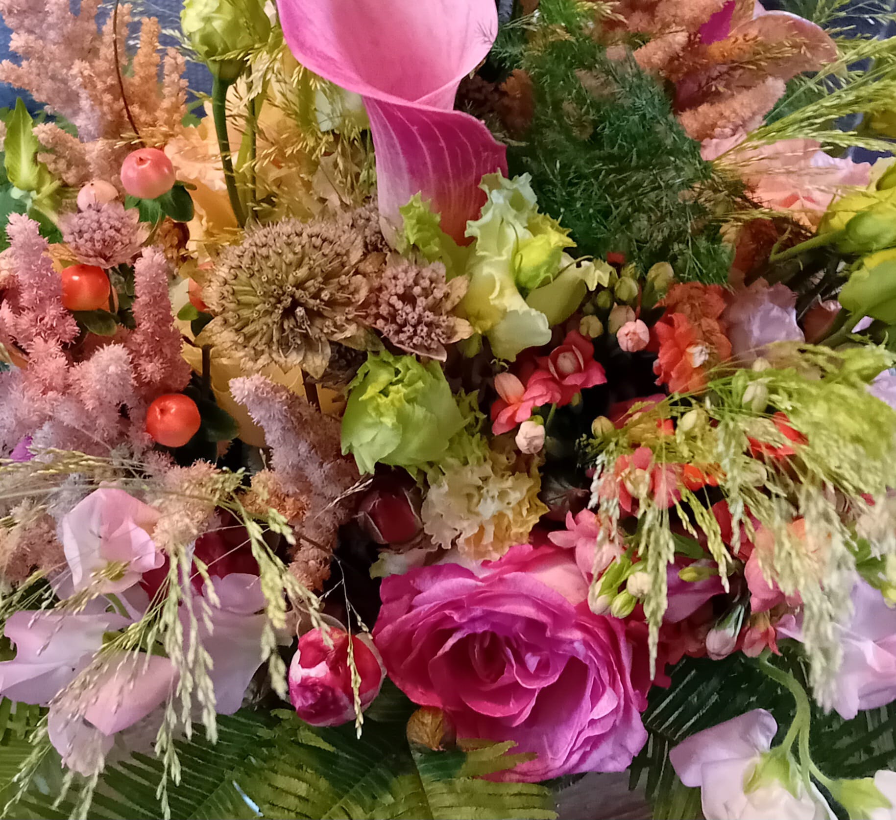 Goed gevulde bos zelf gebonden bloemen in roze tinten, ingezoomd op de bloemen zelf