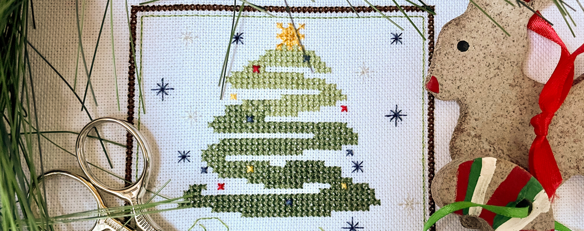 December Free Pattern depicting a Christmas tree with decorated with lights and Christmas balls.