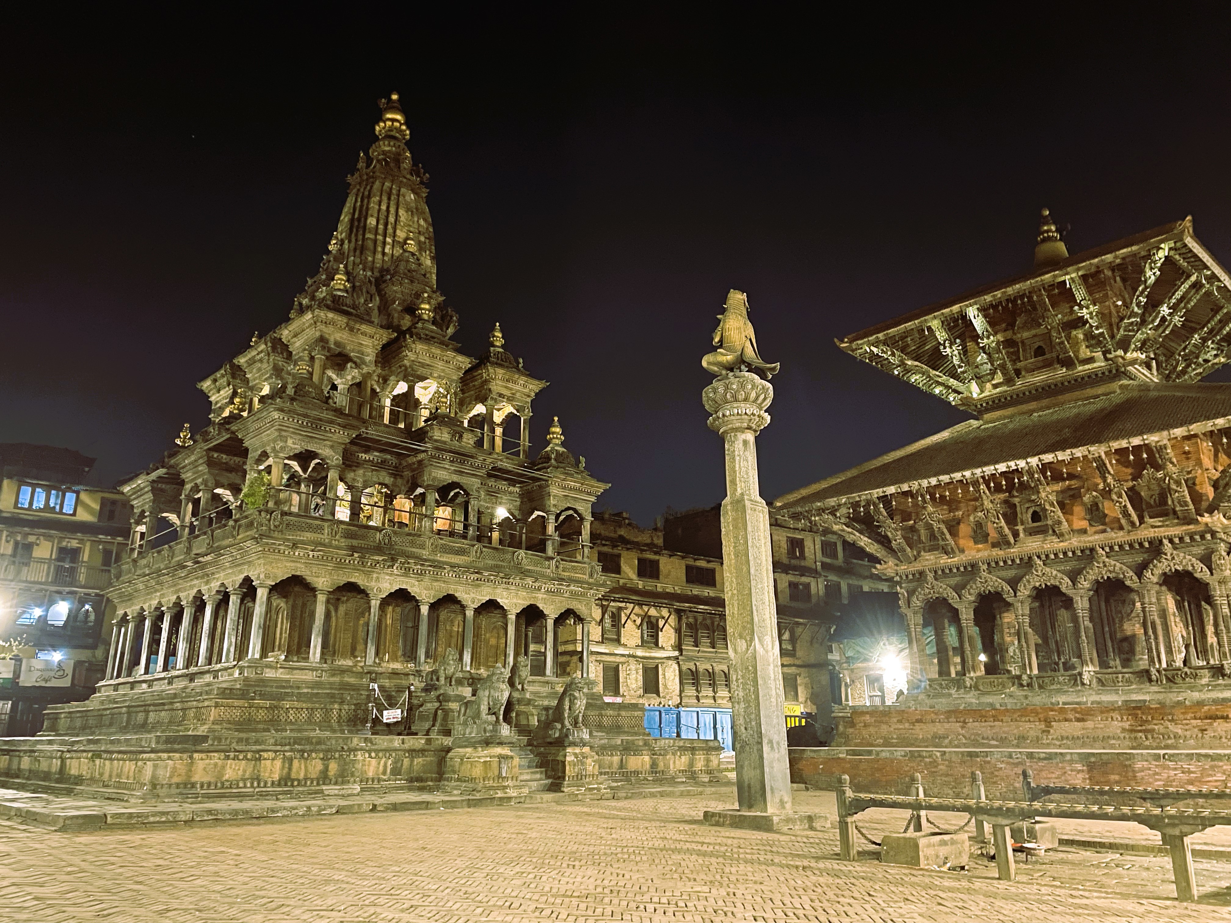 Nighttime view of a town square with two temples