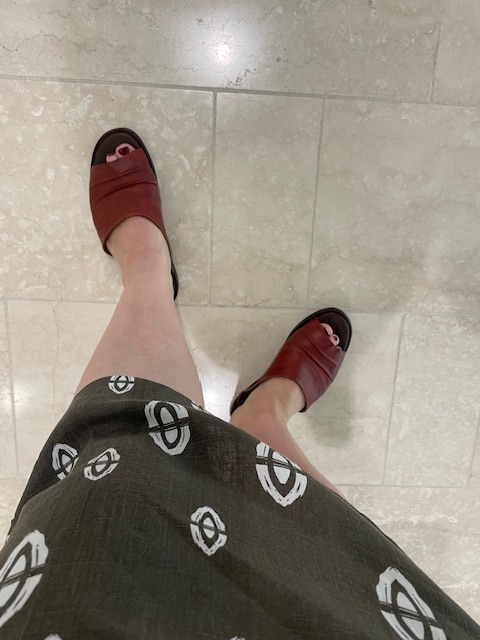Brown leather slide sandals on a woman's feet
