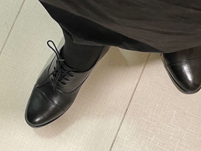 Black oxford tie shoes on a woman's feet