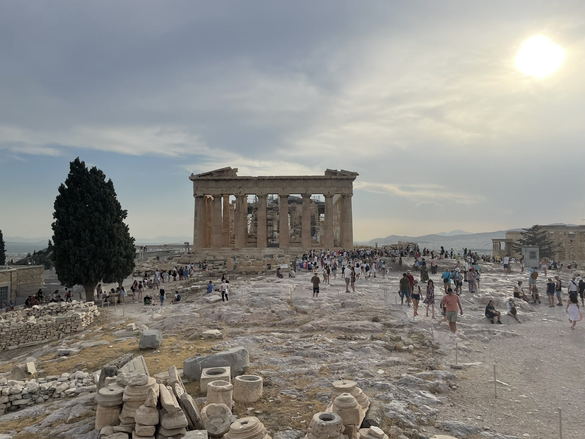 View of Acropolis hilltop, with people milling about in front of the Parthenon