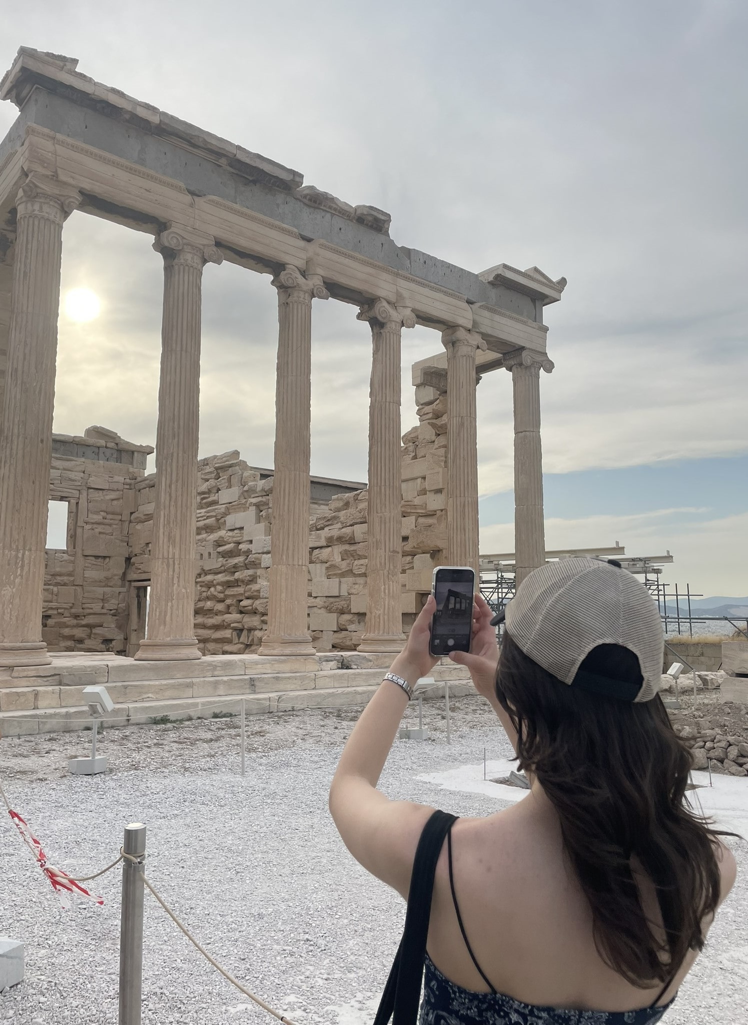 girl taking photo of stone columns