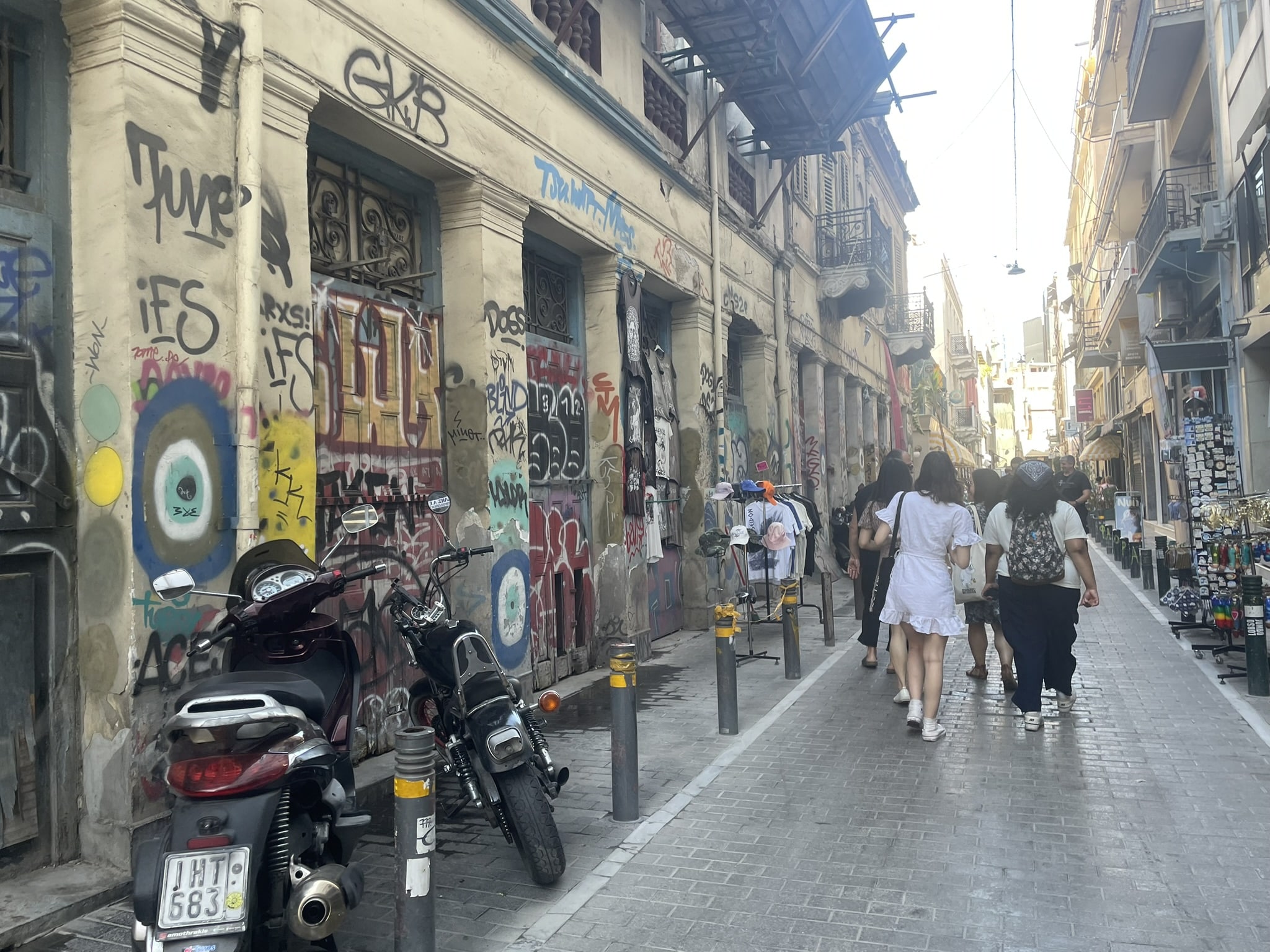 group walking down a street lined with graffiti tagged buildings