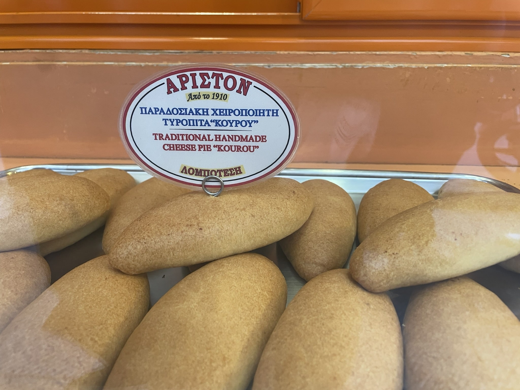 baked rolls with sign says "traditional handmade cheese pie 'kourou'"