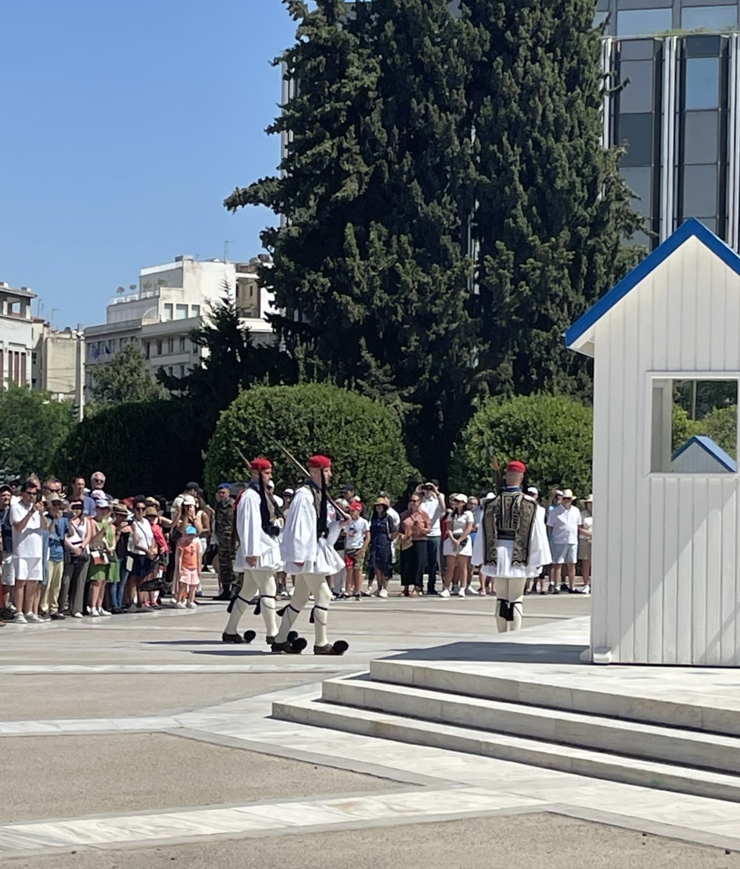 Greek guards in traditional uniforms with red berets and pom poms on shoes
