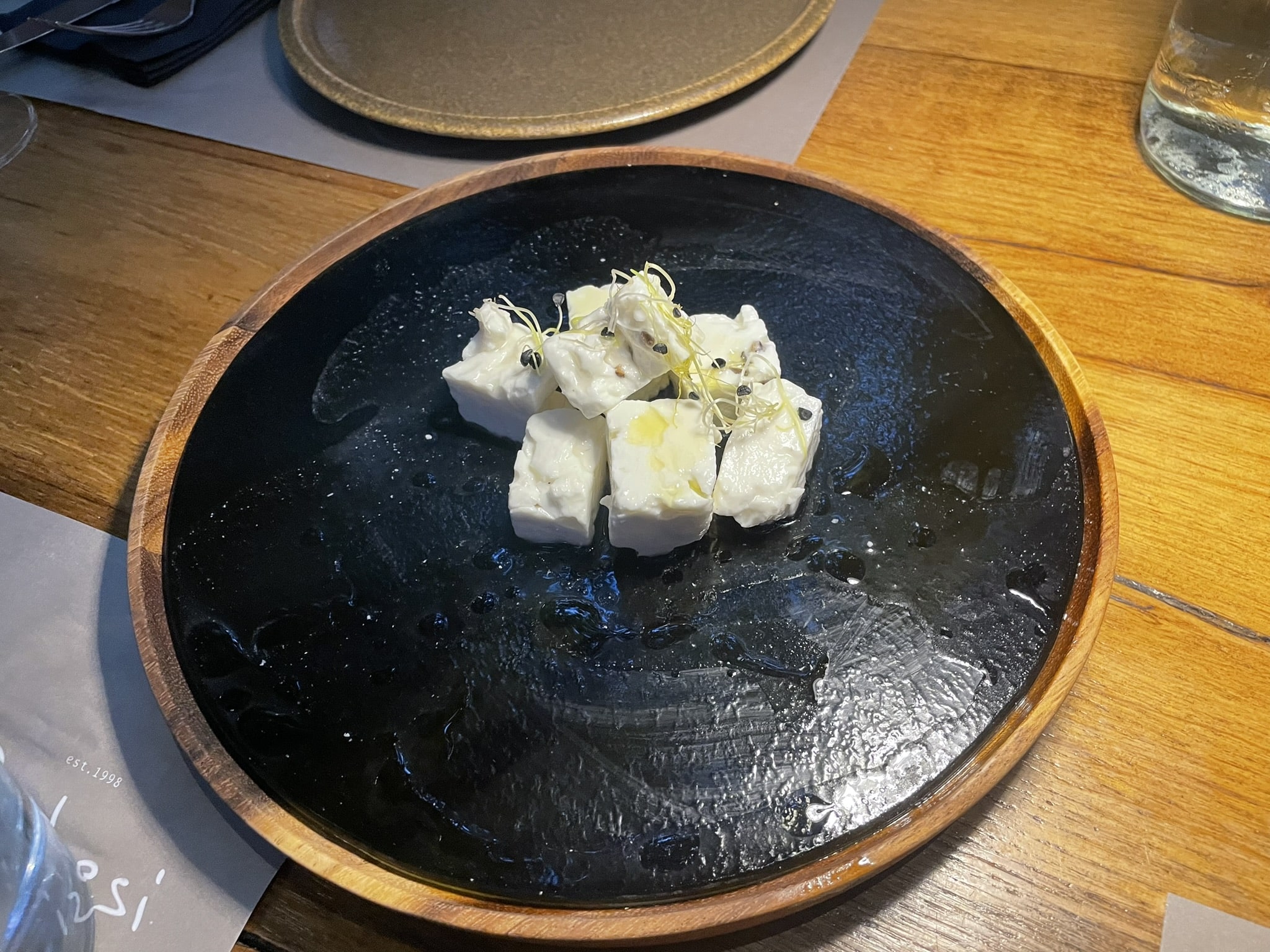 small cubes of white cheese on a black plate