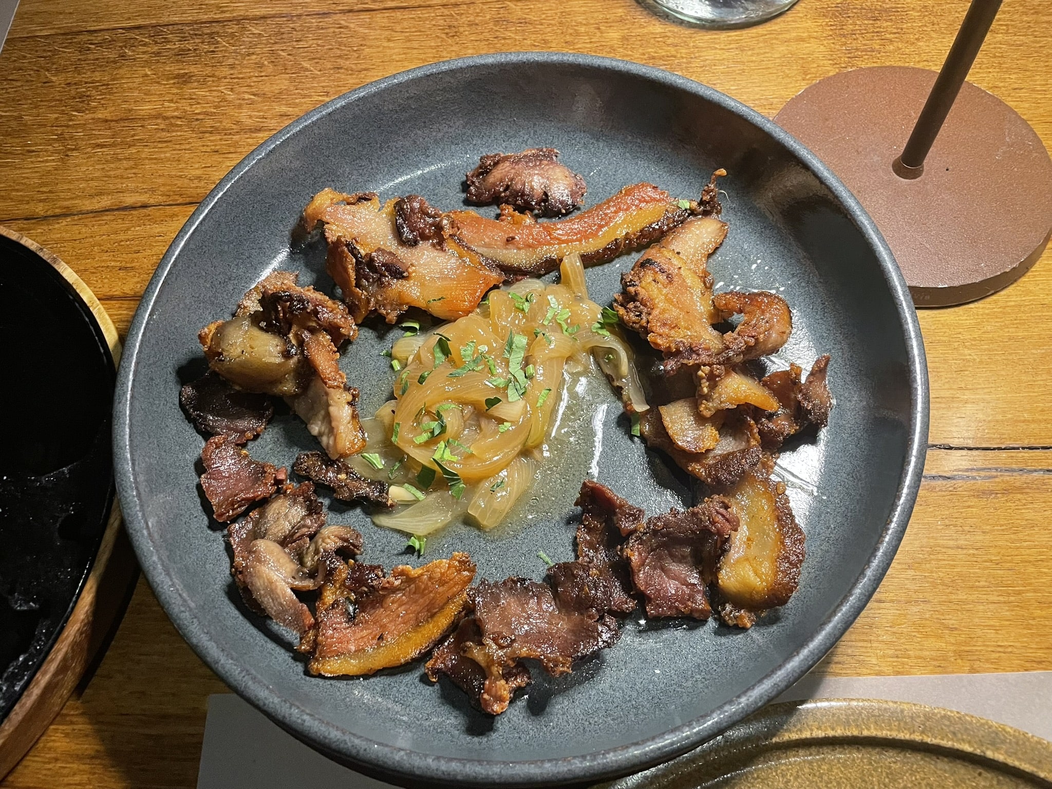 pieces of cured pork arranged around caramelized onions