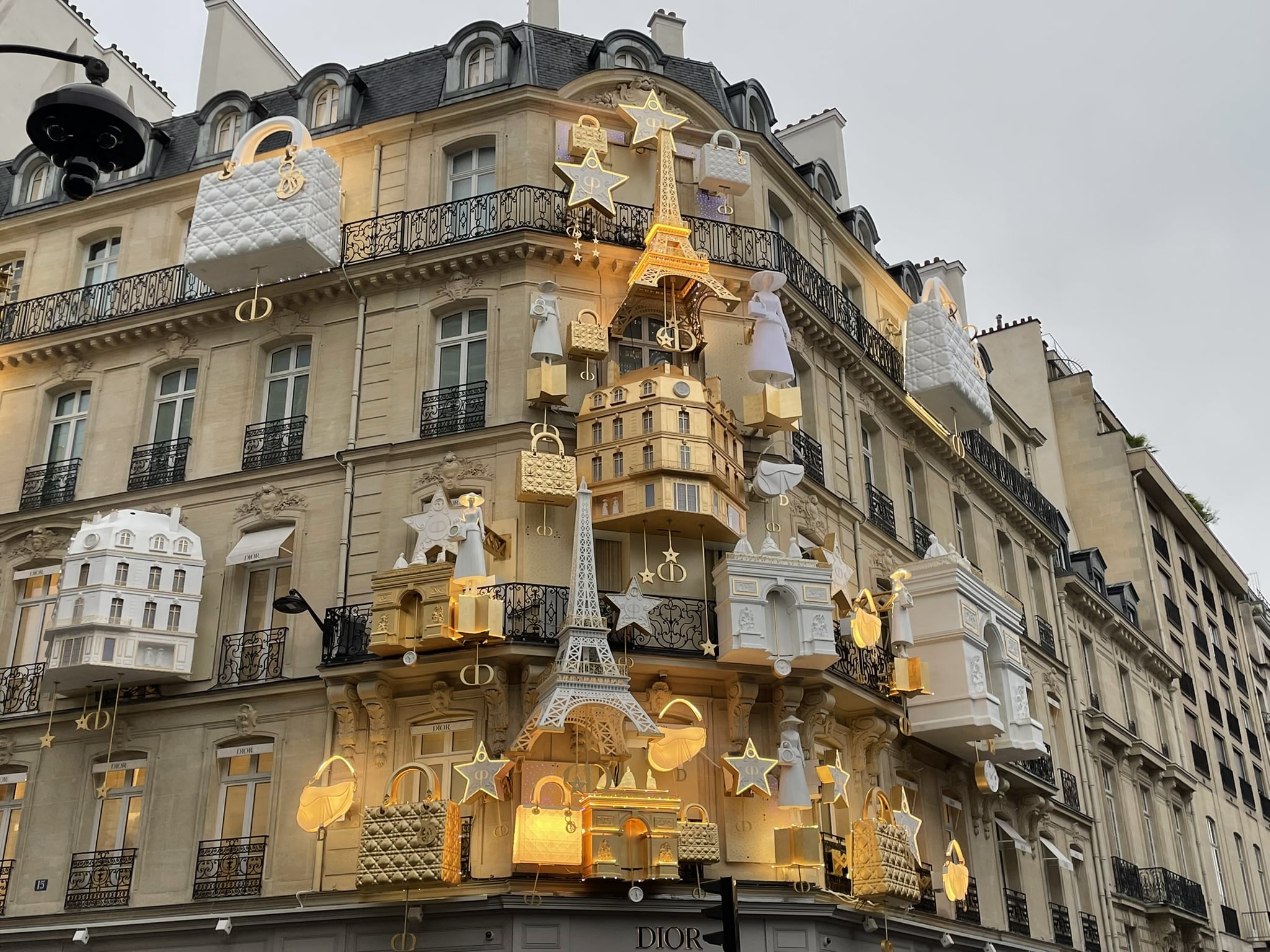 Dior building decorated with gold depictions of Paris including the Eiffel Tower and arc de triomphe