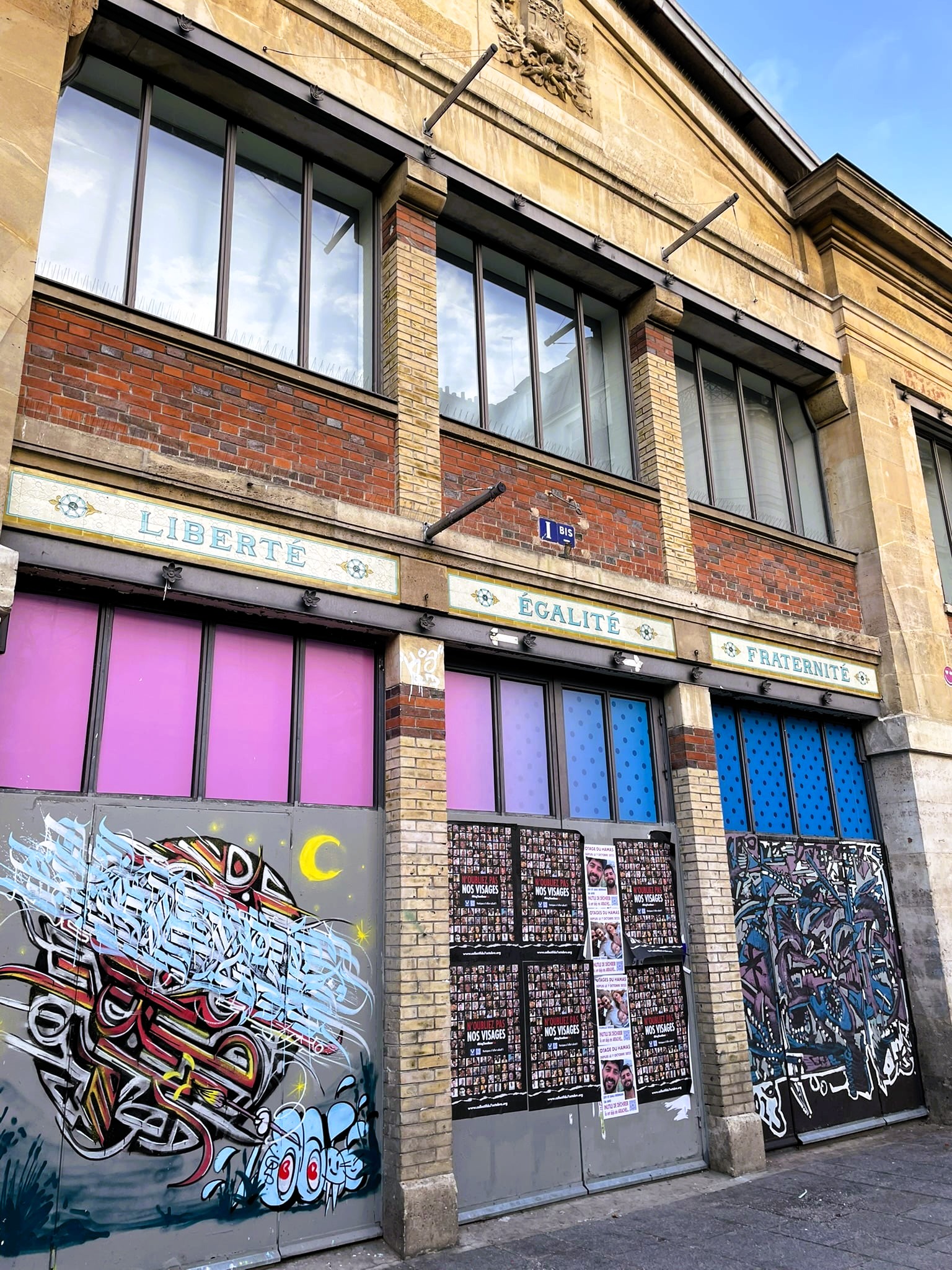 colorful street art below signs reading liberté, égalité, fraternité