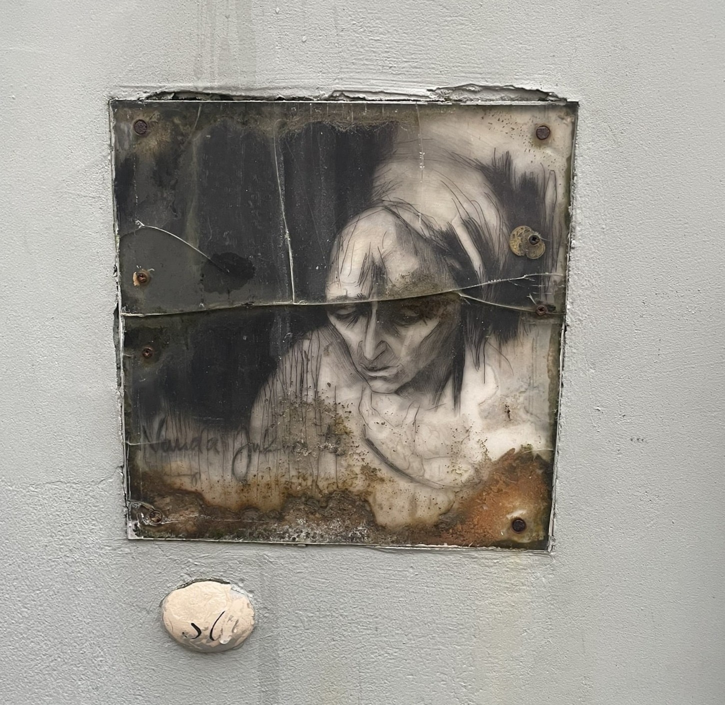 A square tile painted with a sad human figure