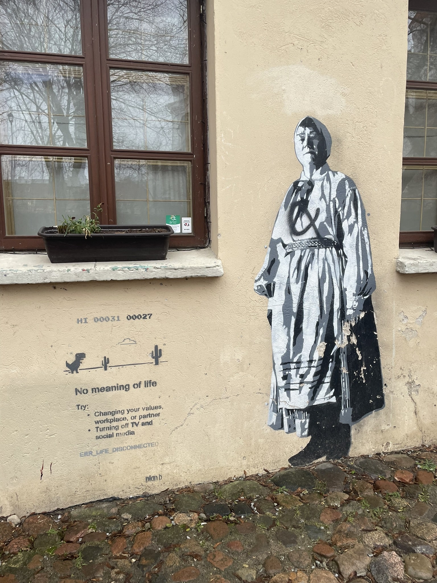 black and white drawing of a woman painted onto a building, between two windows