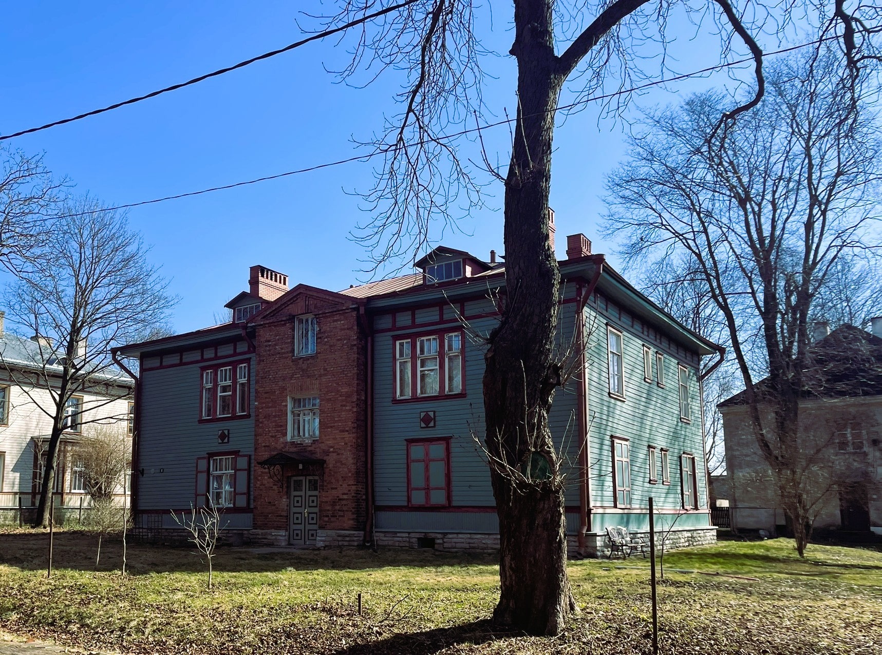 two story wooden house building with red brick center.