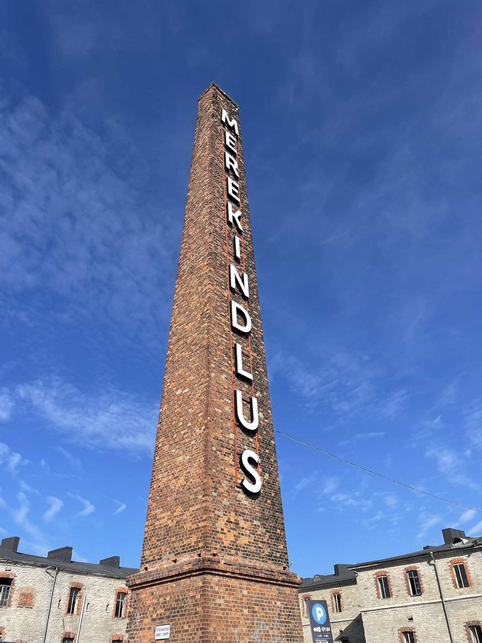 Tall brick chimney emblazoned with white letters spelling our "Merekindlus"
