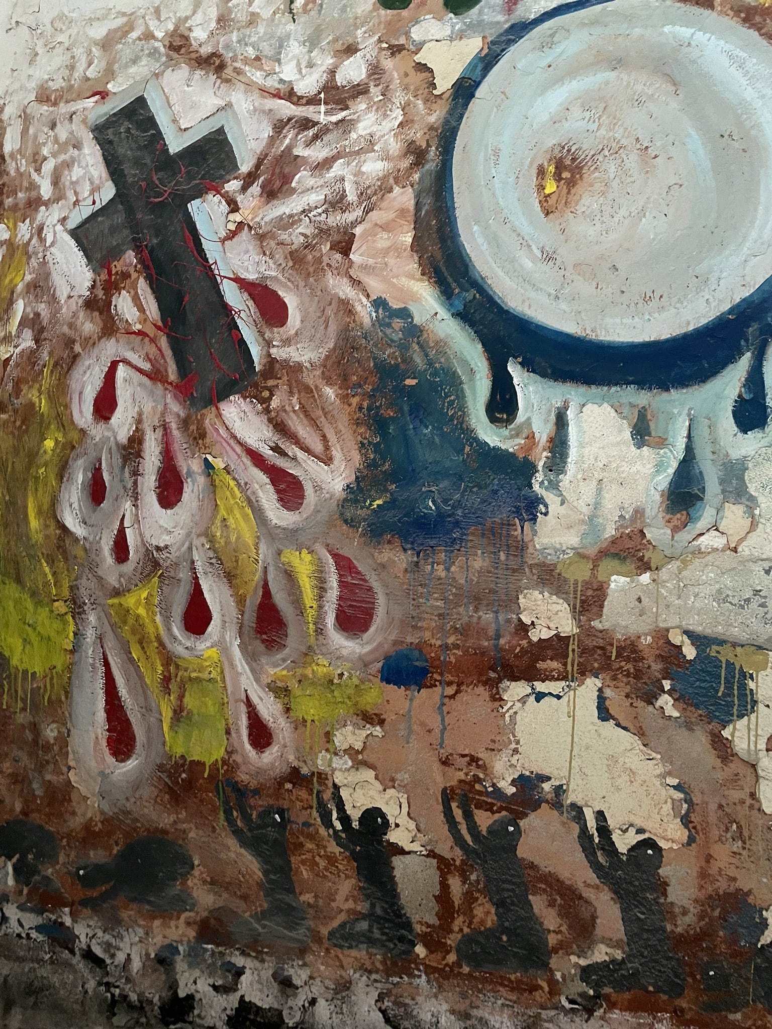 closeup detail of a wall mural depicting a black cross with blood dripping off, and several shadow figures below with arms outstretched towards the cross