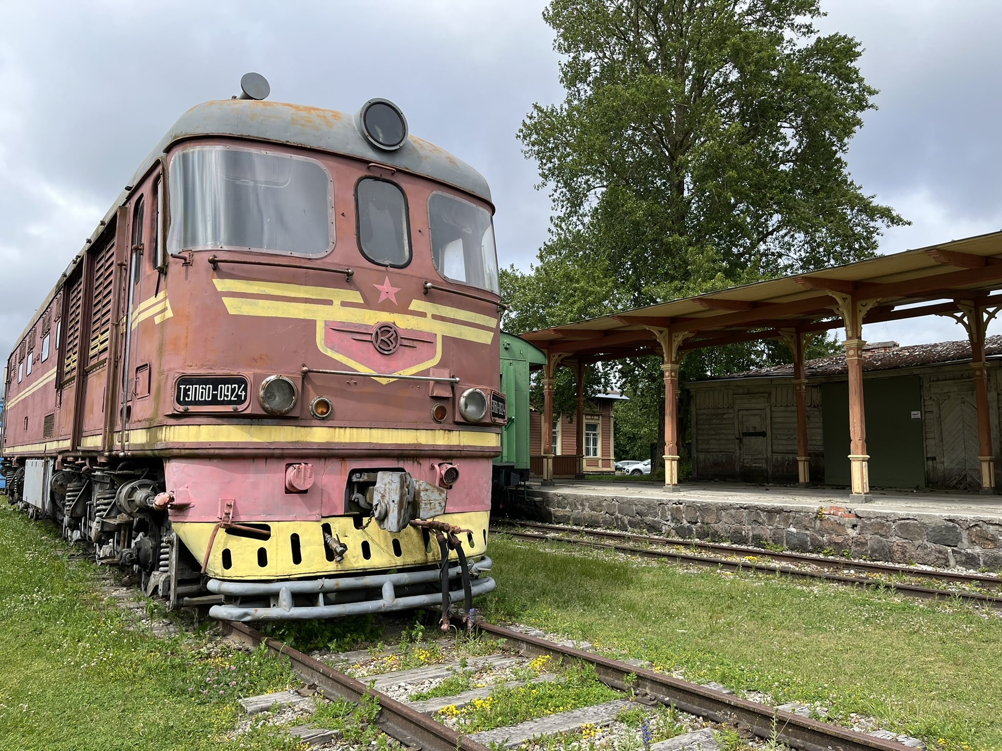 Train engine painted a faded red and cold, with a gold star right below the window