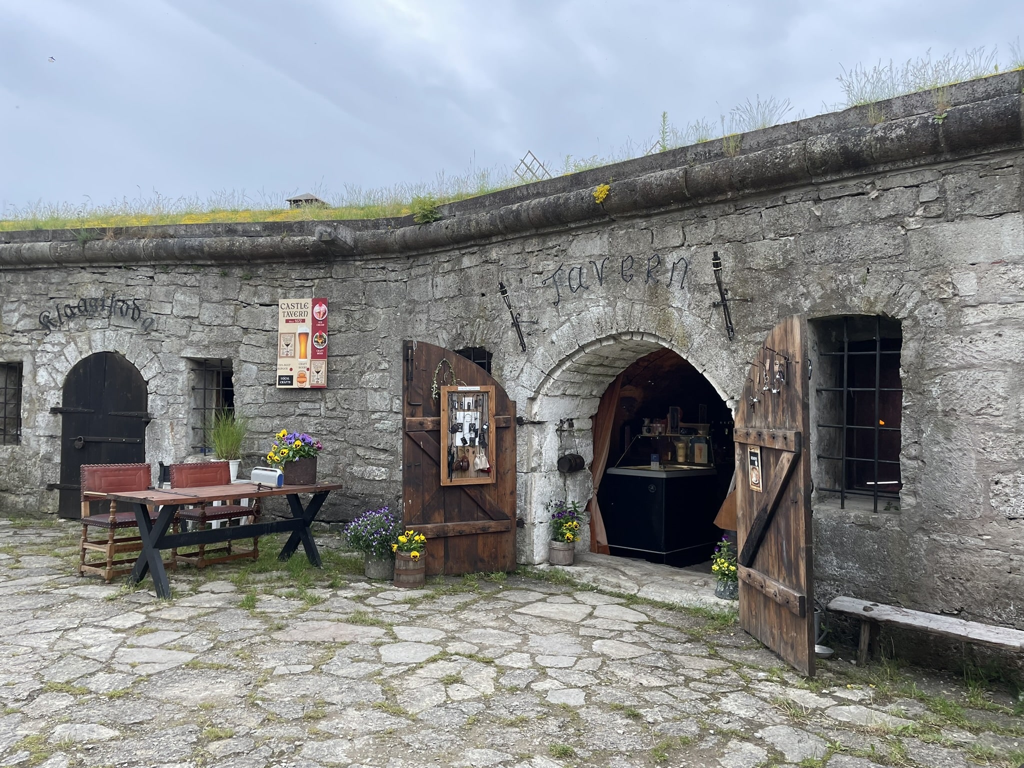 Arched grey stone storway signed "tavern"
