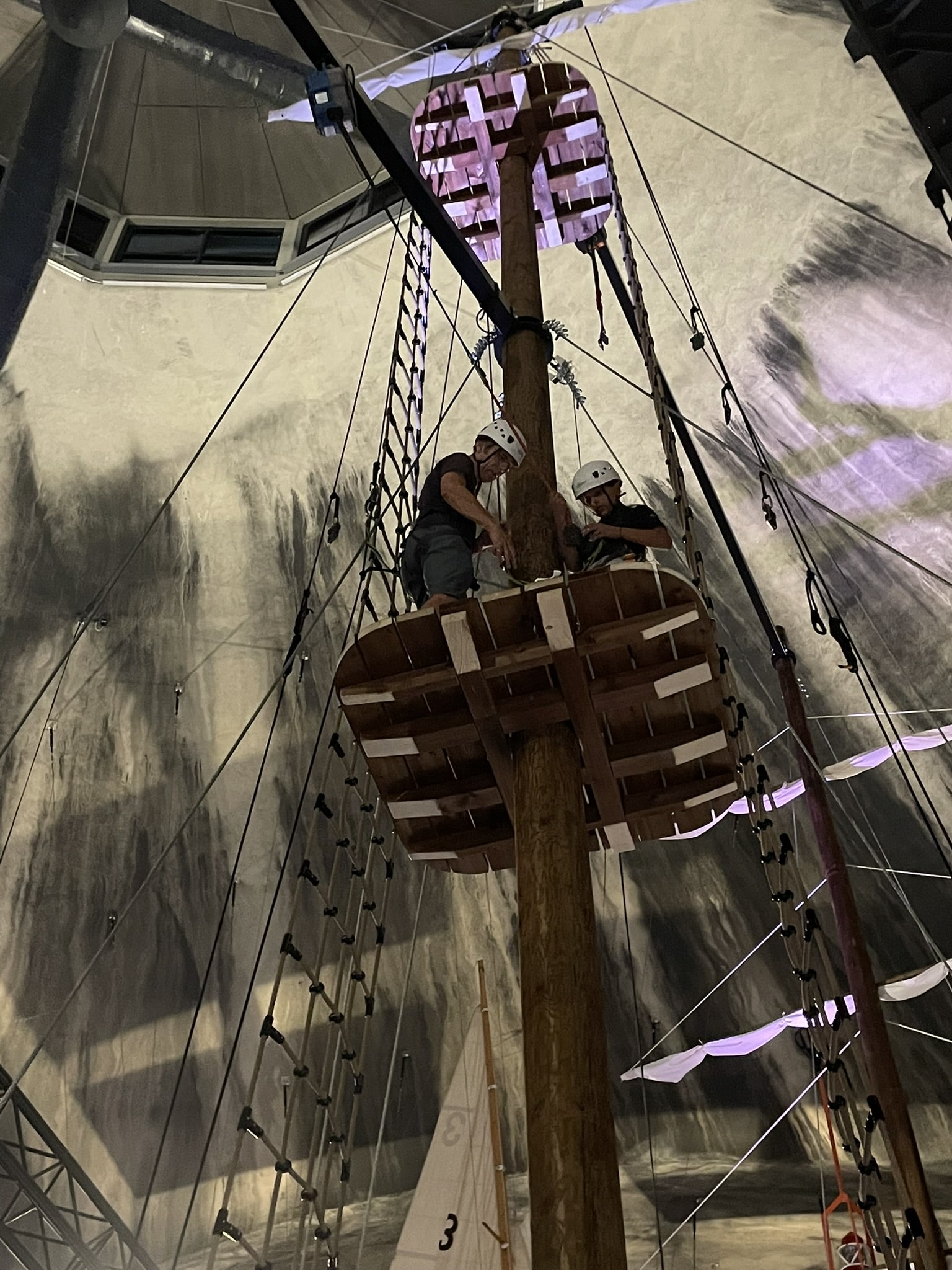 A man and girl atop a ship's mast