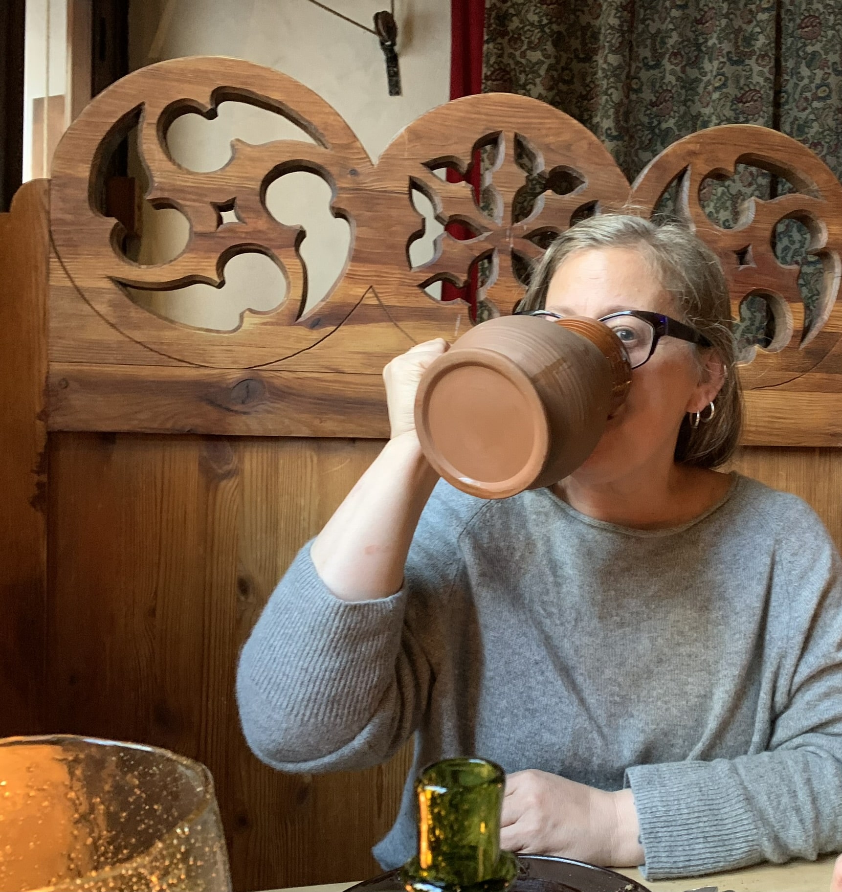 Woman drinking from a large terracotta mug