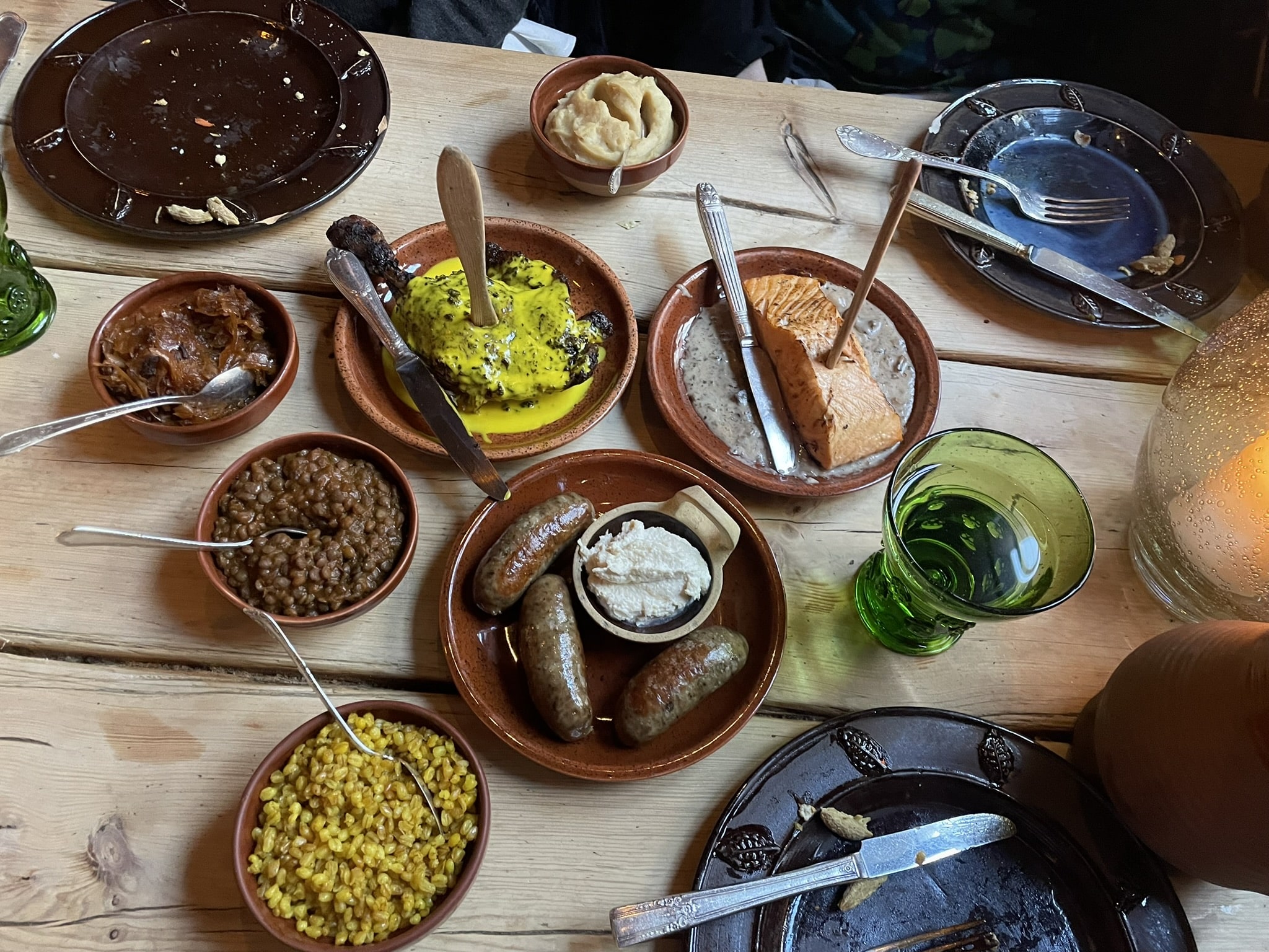Plates full of food including lentils, sausage, and salmon.