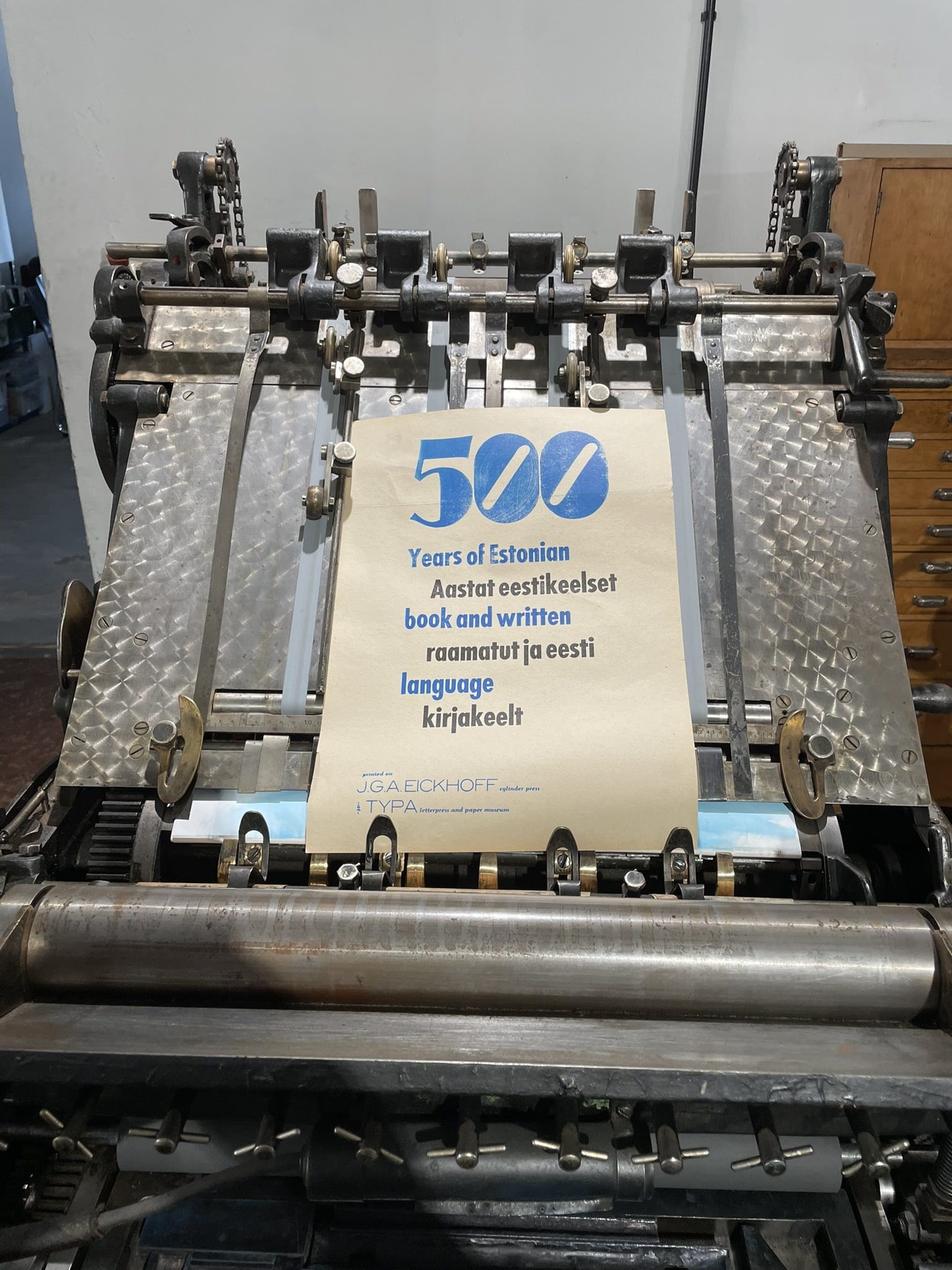 Printing press with a leaflet proclaiming 500 years of Estonian books/written language