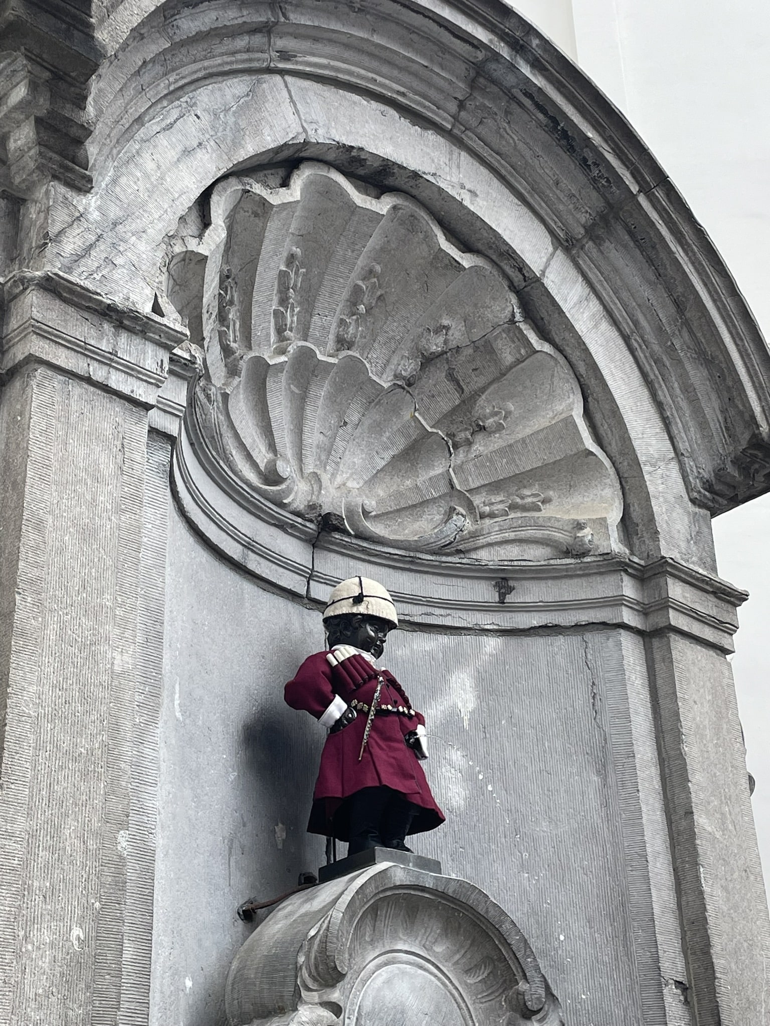 manneken pis statue in a red velvet costume