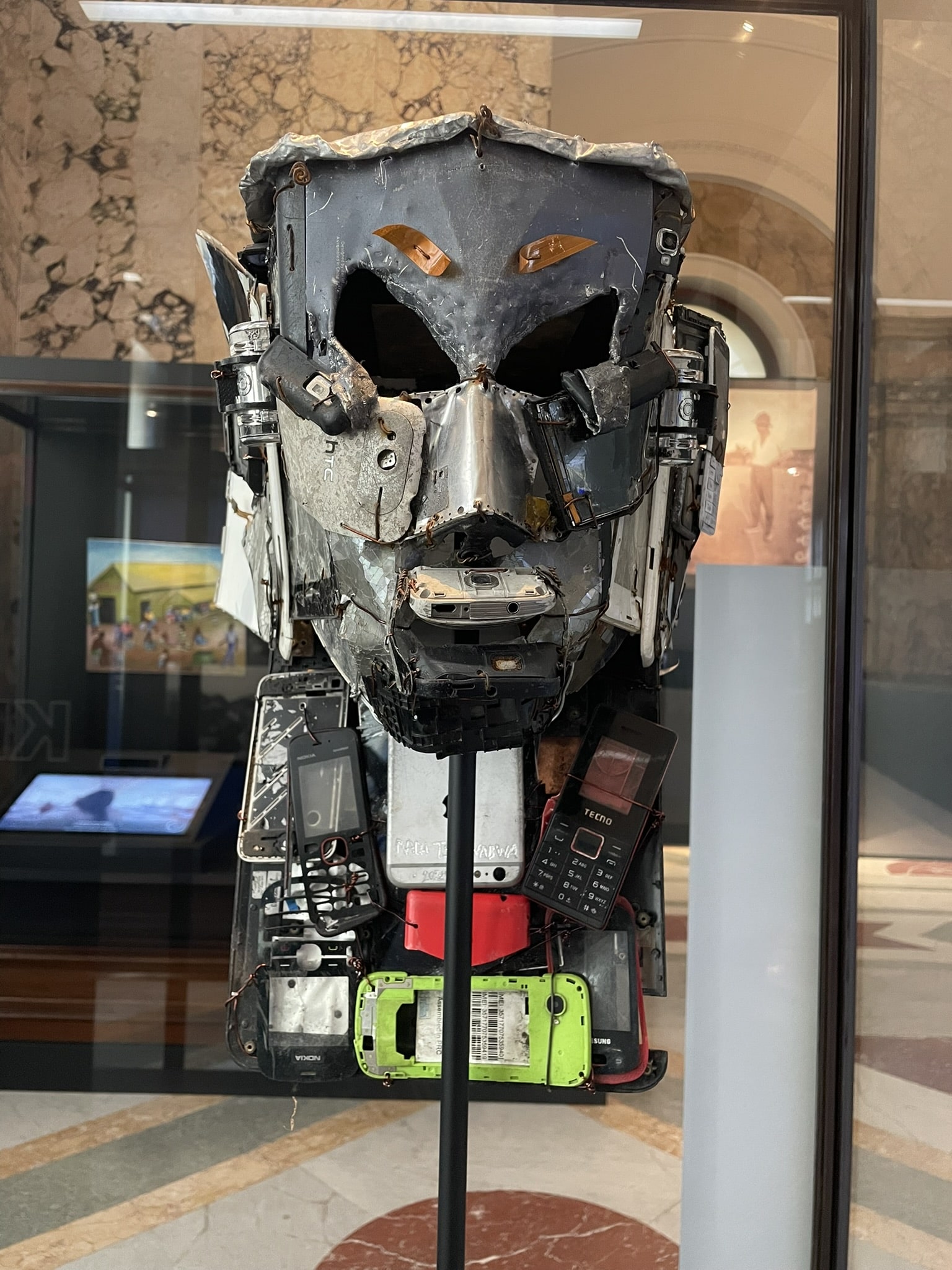 traditional mask crafted from scap metal and old cell phones