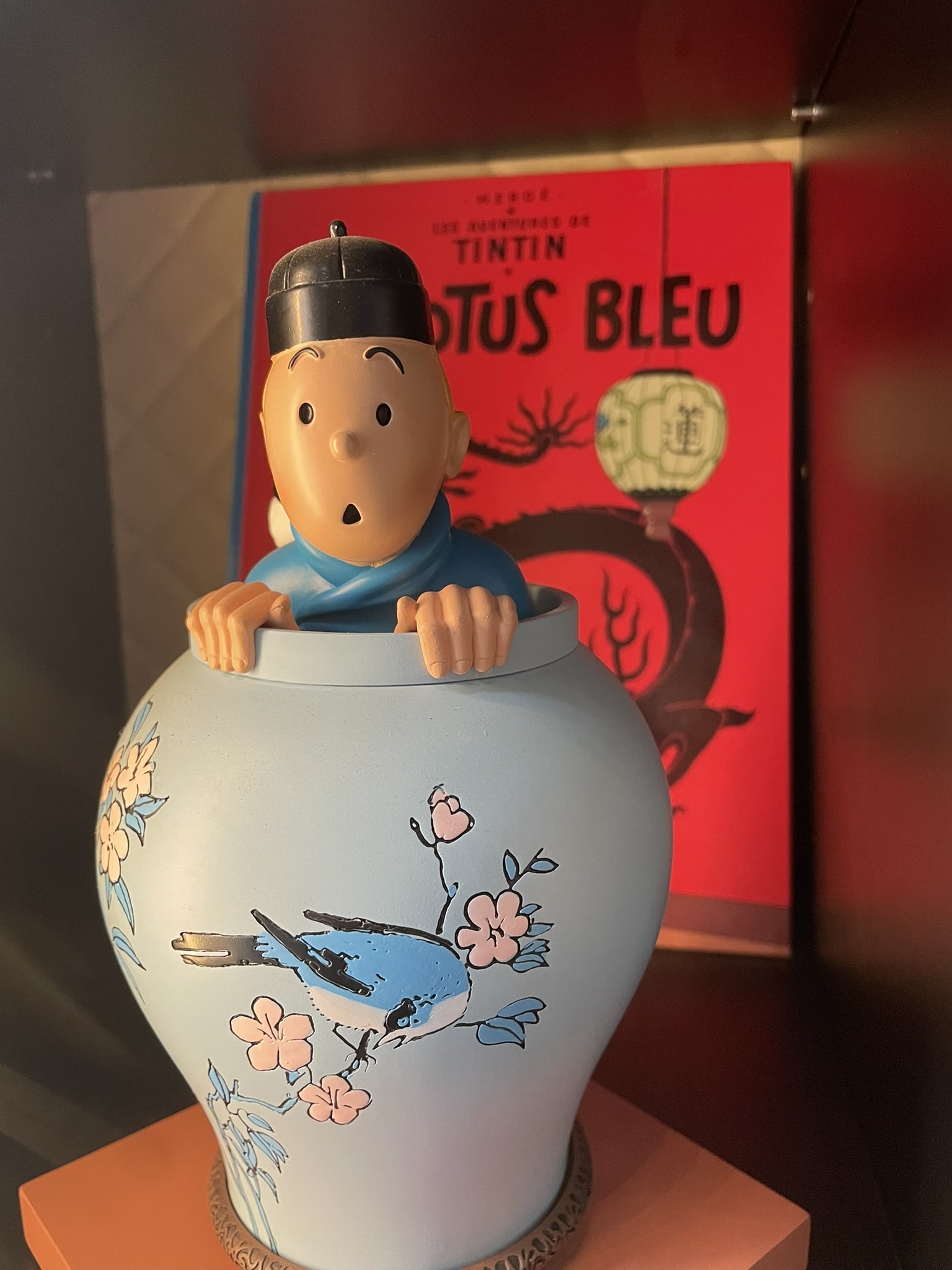 ceramin statue of a figure (Tin Tin) peeking out of a large vase