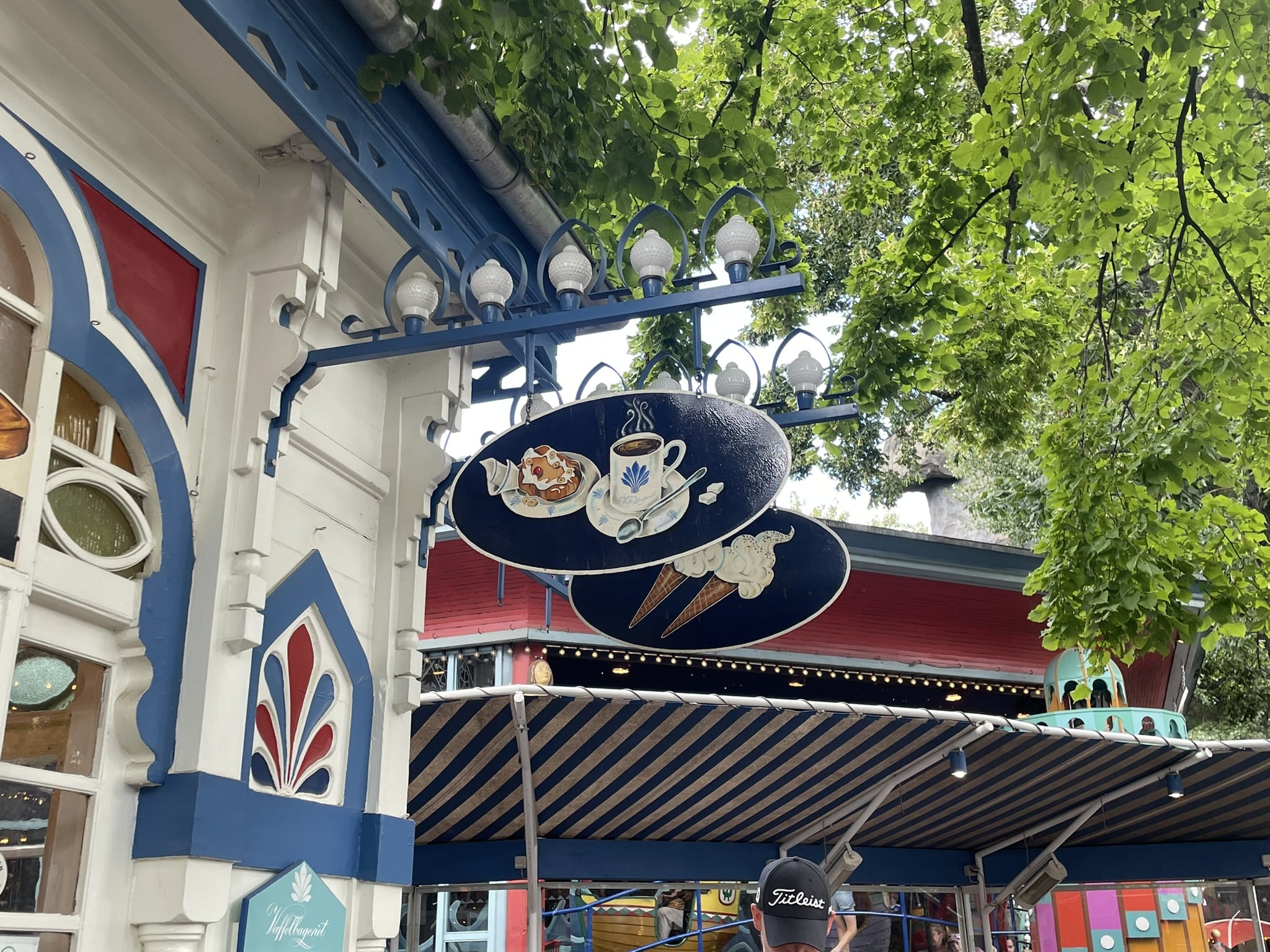 hanging shop sign displaying pictures of ice cream, coffee, and pastriy