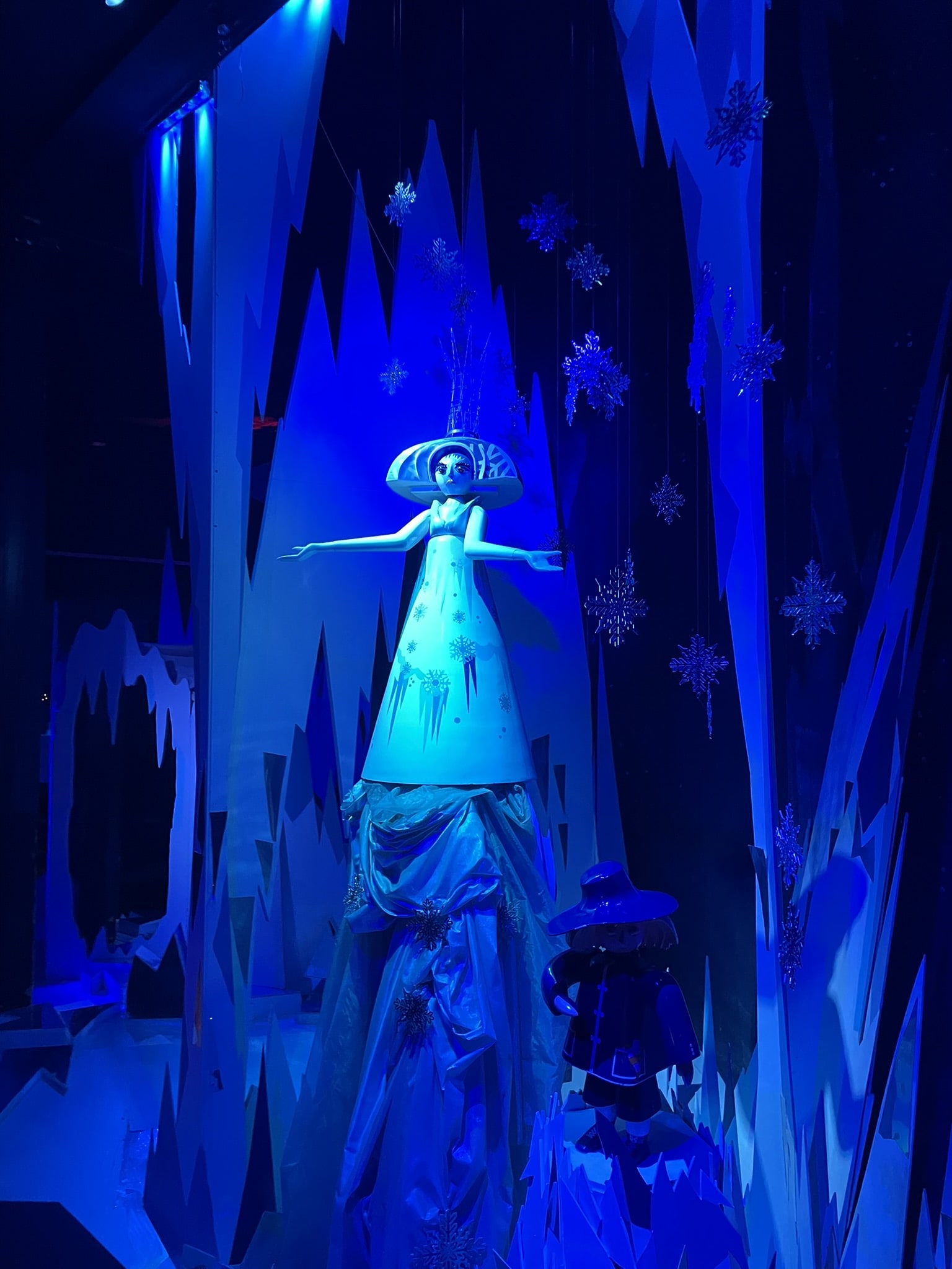 cartoon like statue of a young woman wearing white against a blue background