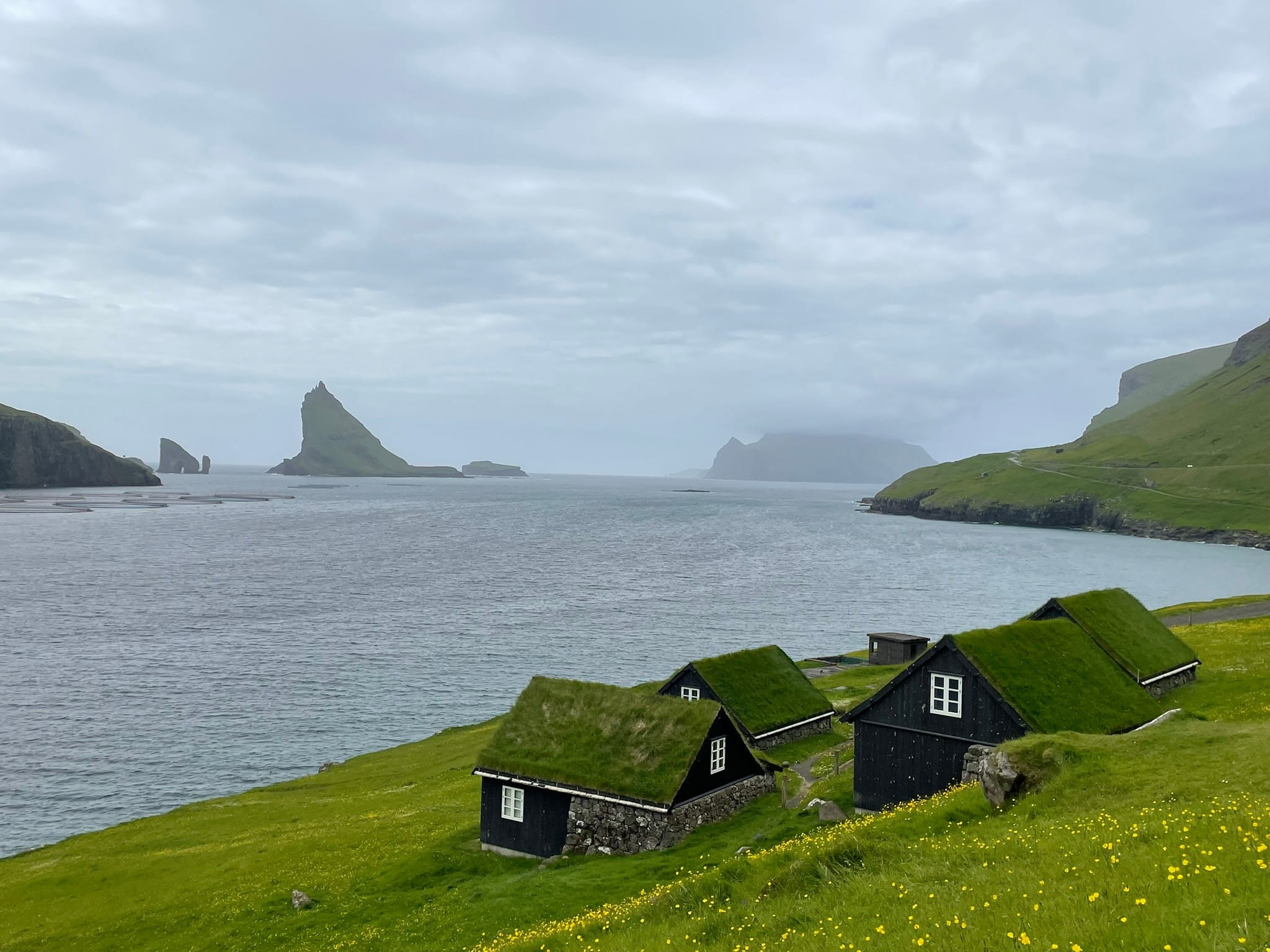 dorsal fin like island in the distance, with turf roofed houses in the foreground