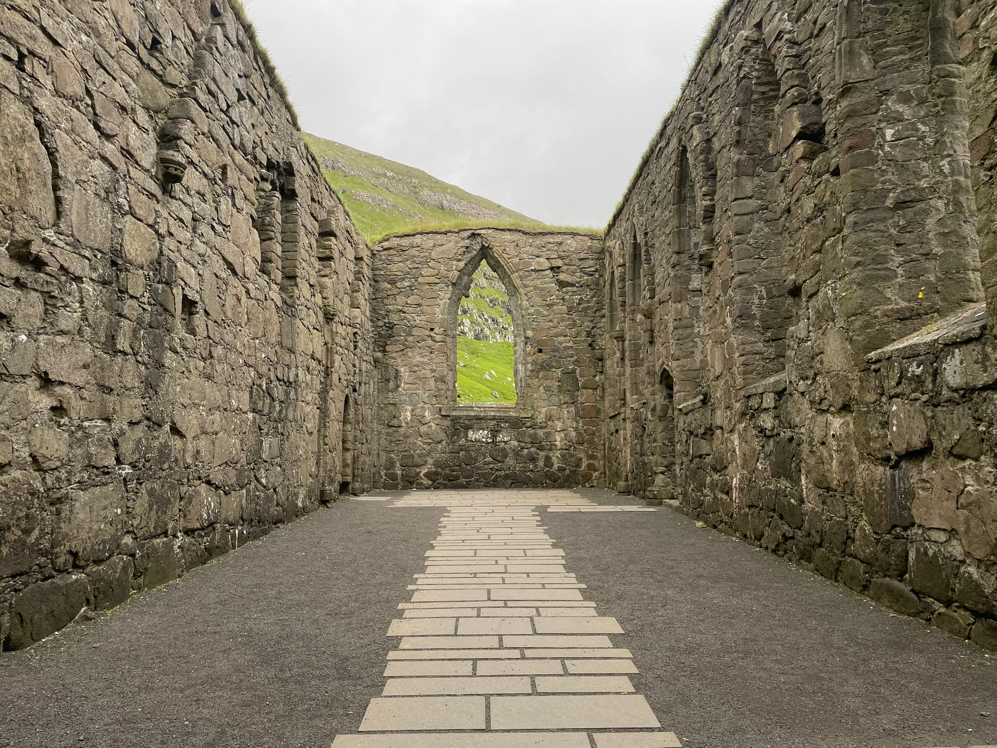 Interior of a stone building with no roof and peaked window