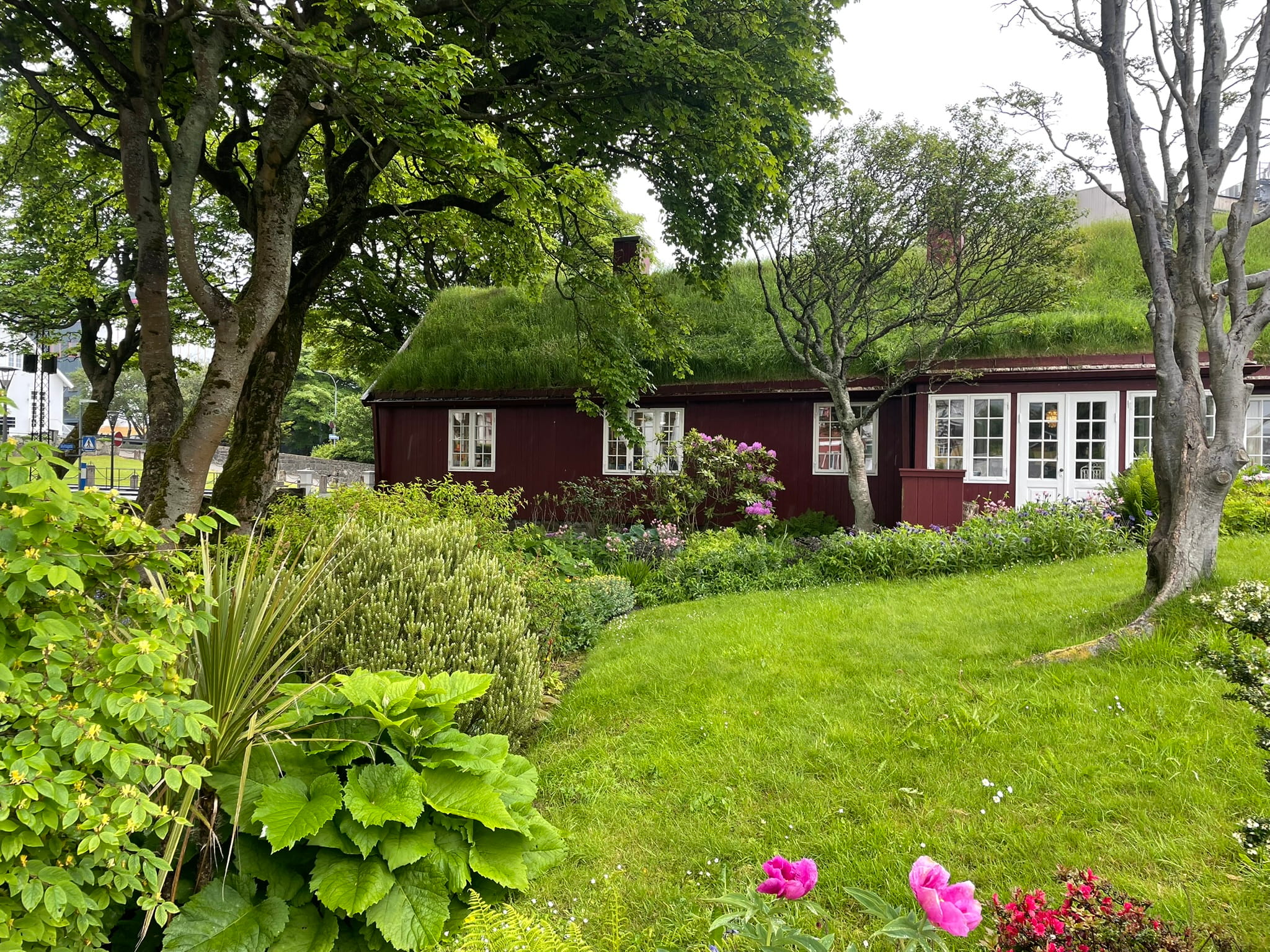 red turf-roofed building fronted by a garden