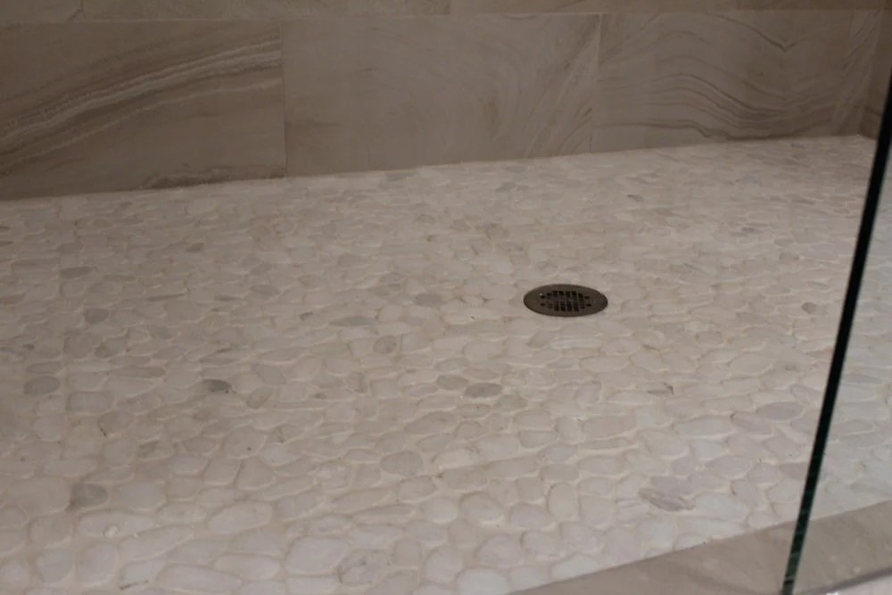 Snowflake Pebbles Mosaic installed in a shower base