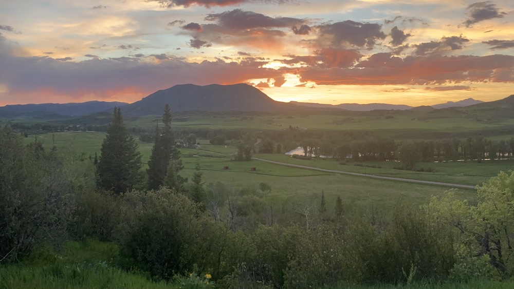 Mountain rising above a green valley at sunset