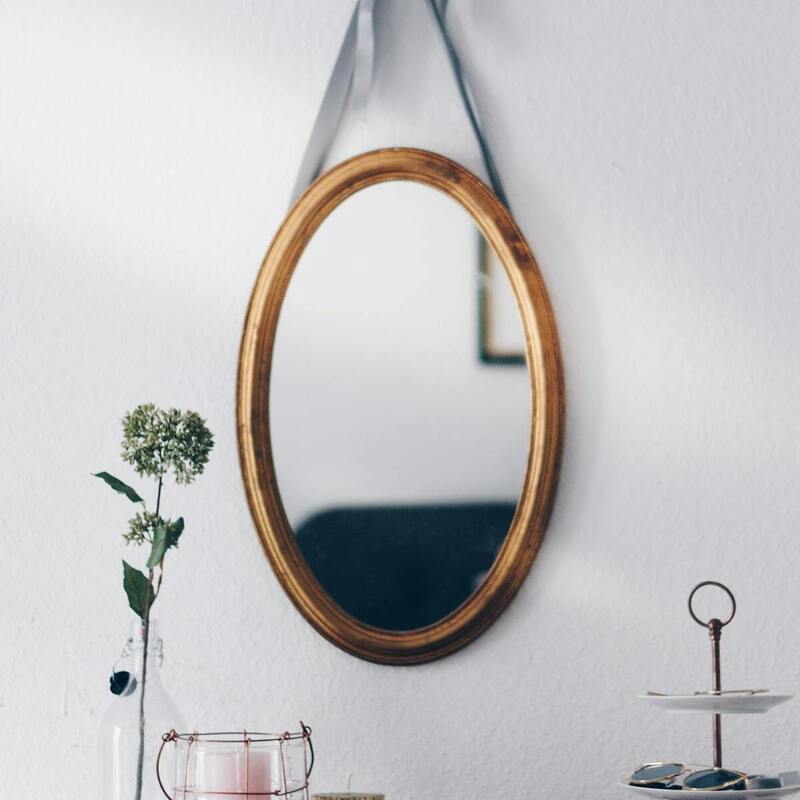 A decorative oval mirror is mounted on the wall, positioned above a table, enhancing the room's elegance and light. Credits: Photo by Nadine Wuchenauer on Pexels