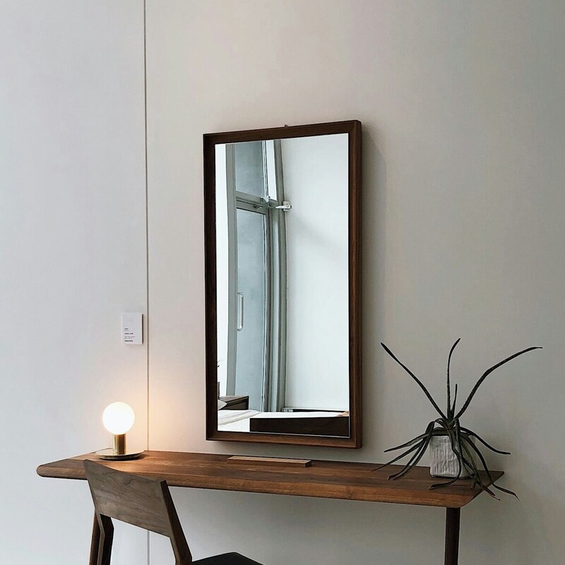 A stylish desk with a mirror above it and a comfortable chair positioned in front, creating a cozy workspace. Credits: Photo by Kirill on Unsplash