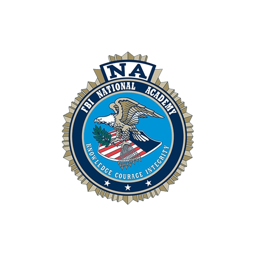 FBI National Academy emblem with eagle, shield, arrows, olive branch, and motto "Knowledge Courage Integrity".