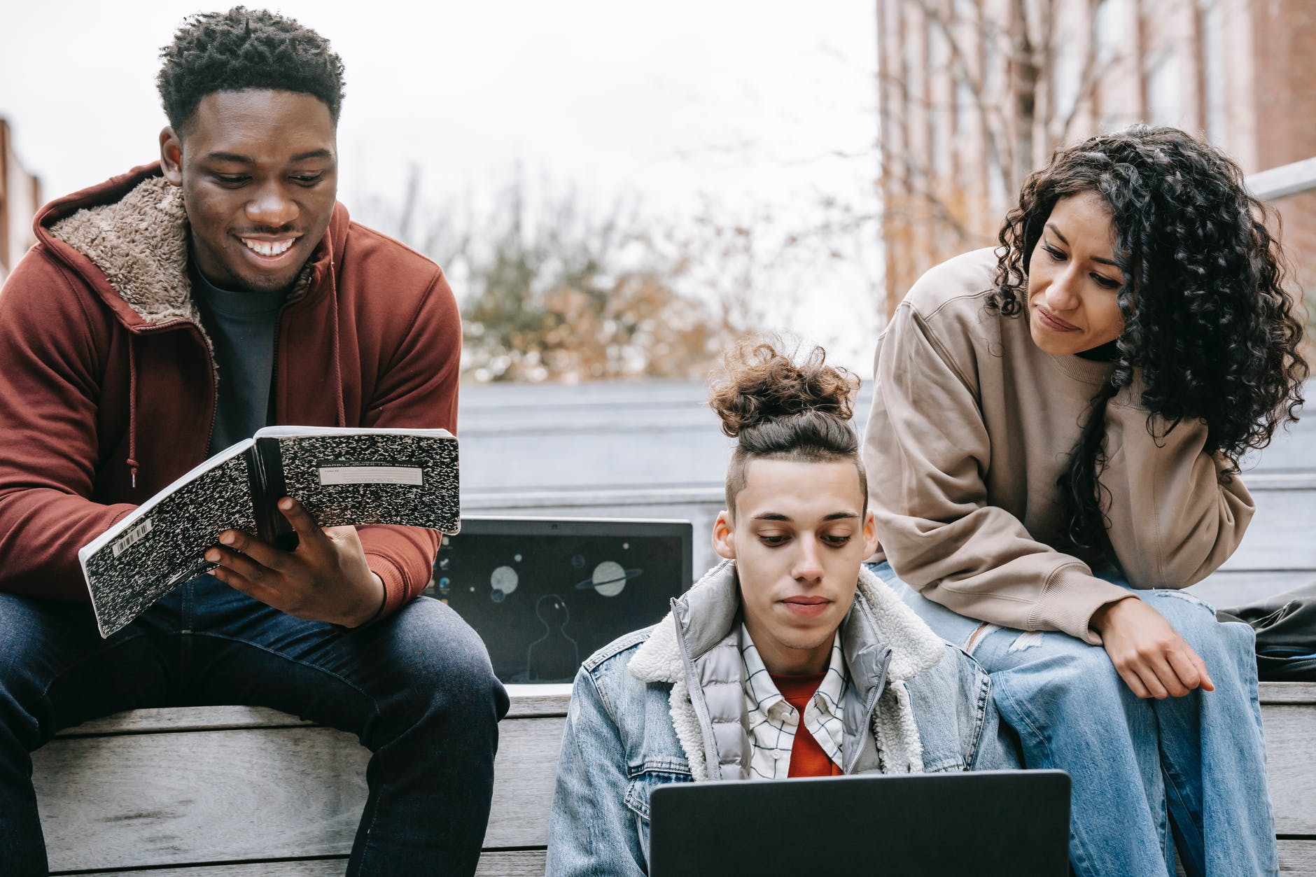 multiethnic group of young people studying with notebook and laptop