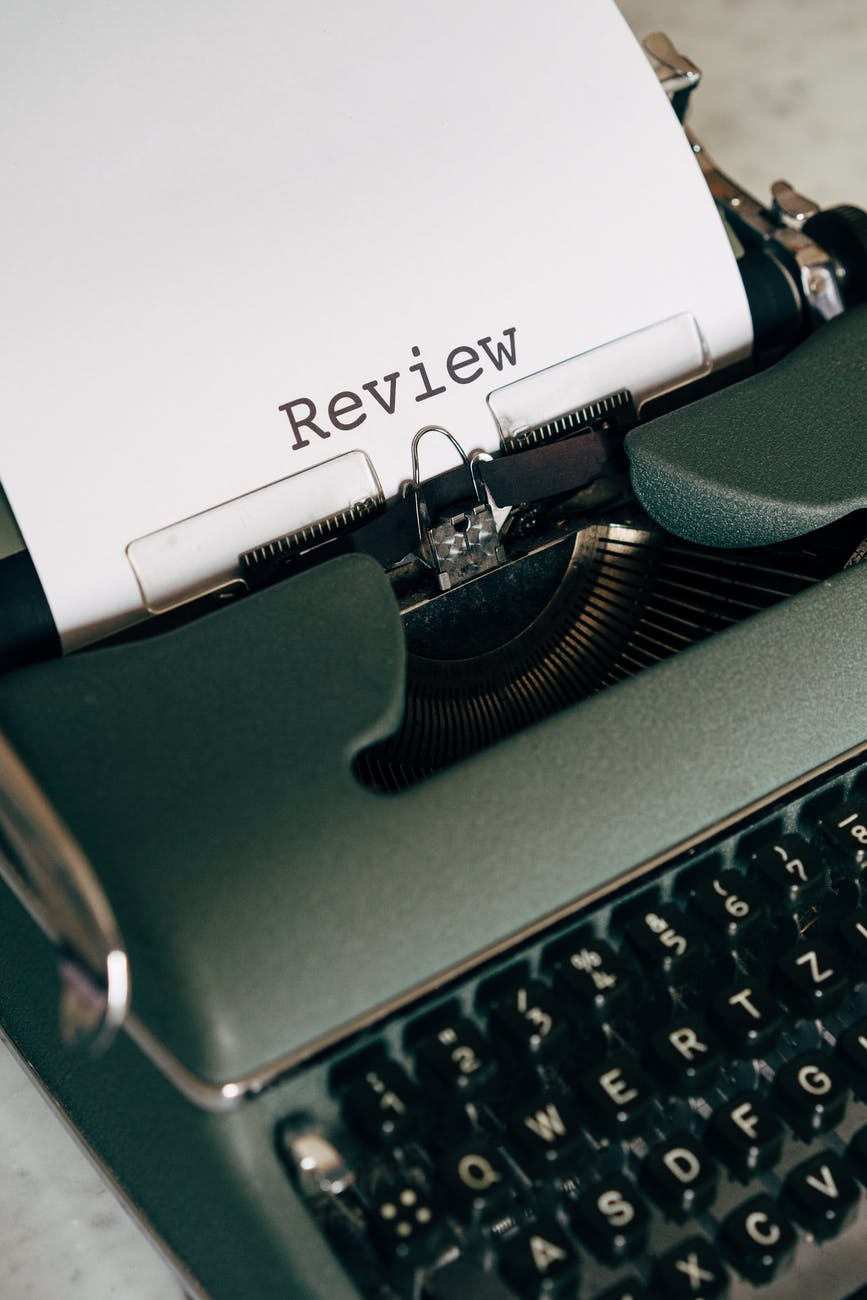 green and white typewriter on brown wooden table