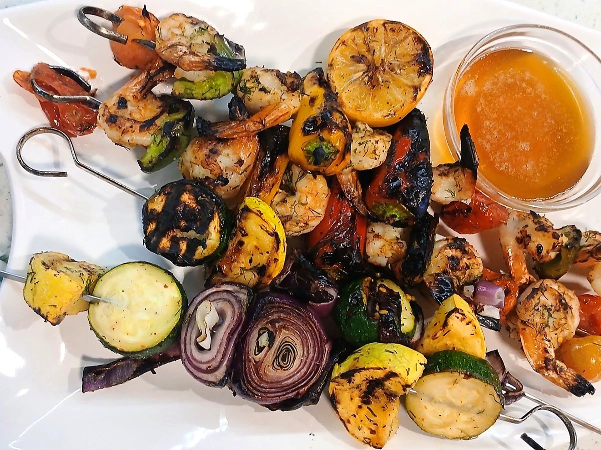 Grilled shrimp skewers with vegetables, charred lemon and browned butter