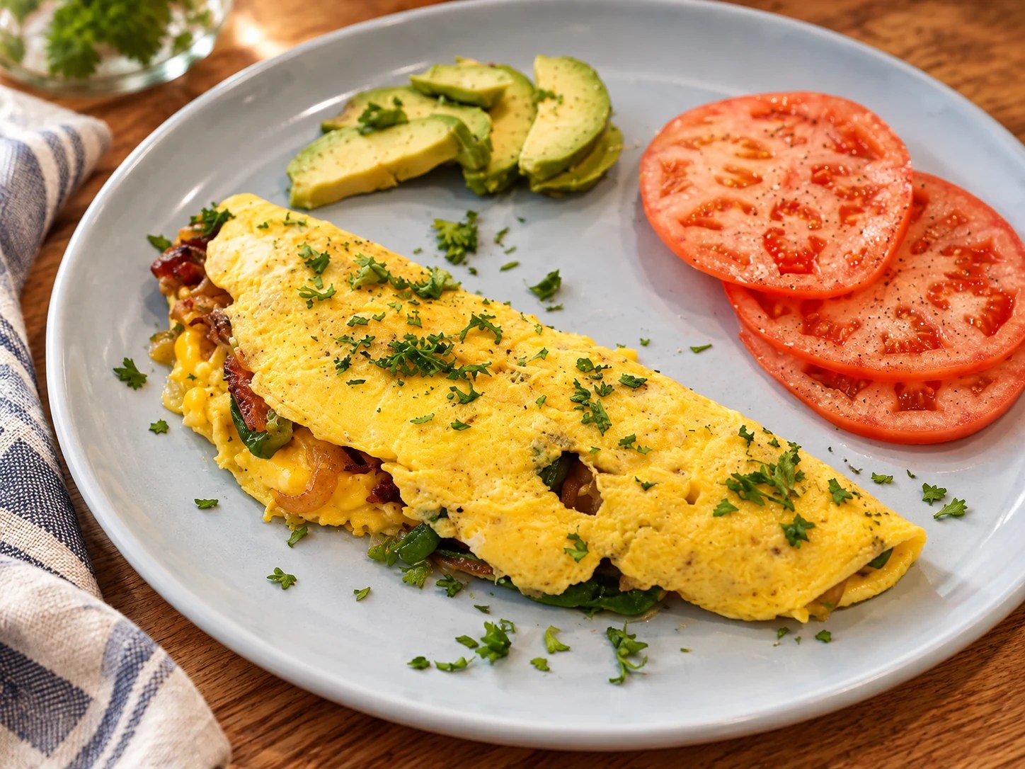 Savory French Omelet with tomato and avocado on a plate, updated photograph