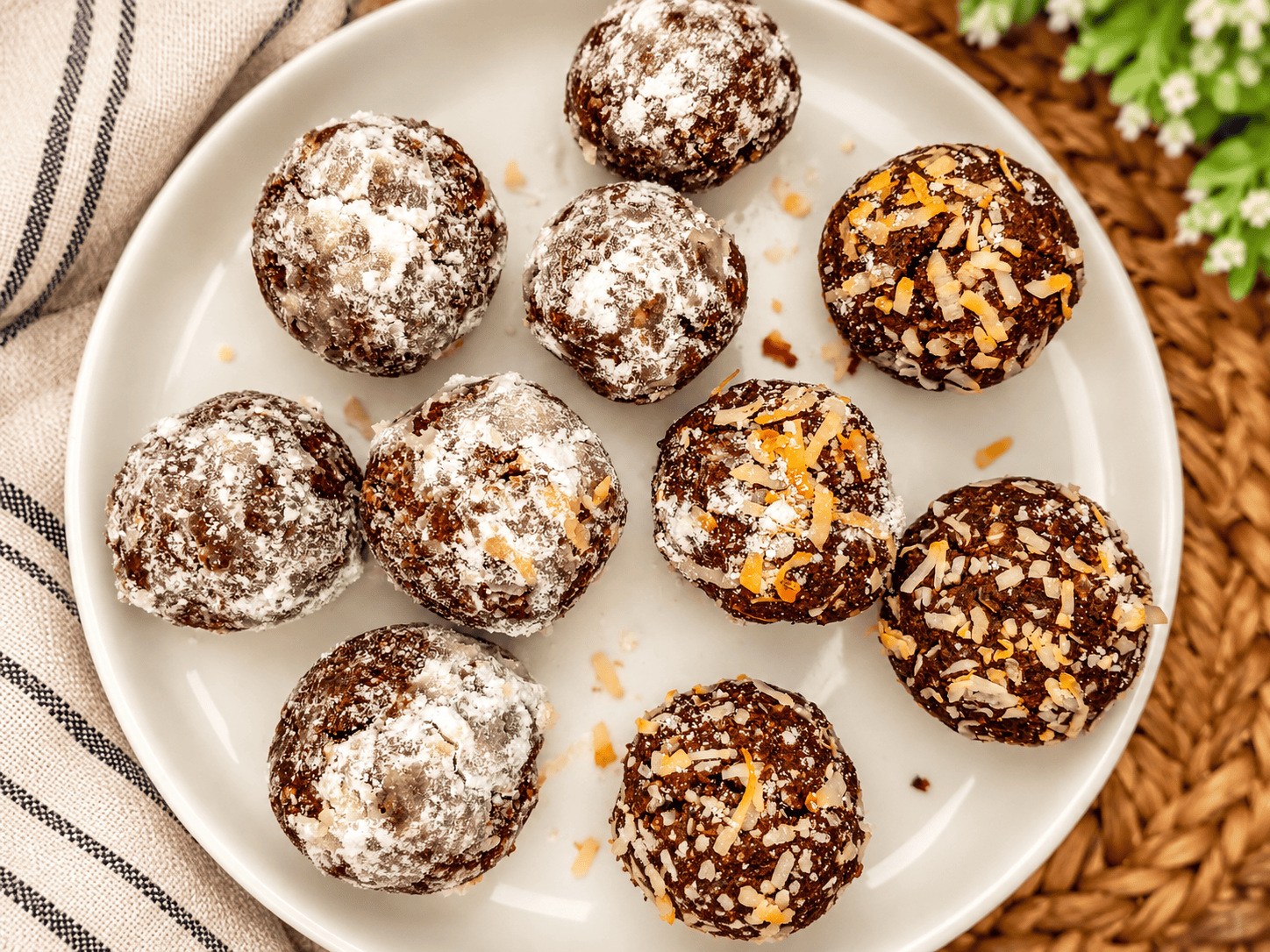 Chocolate coconut fat bomb bites dusted with coconut on a white serving plate