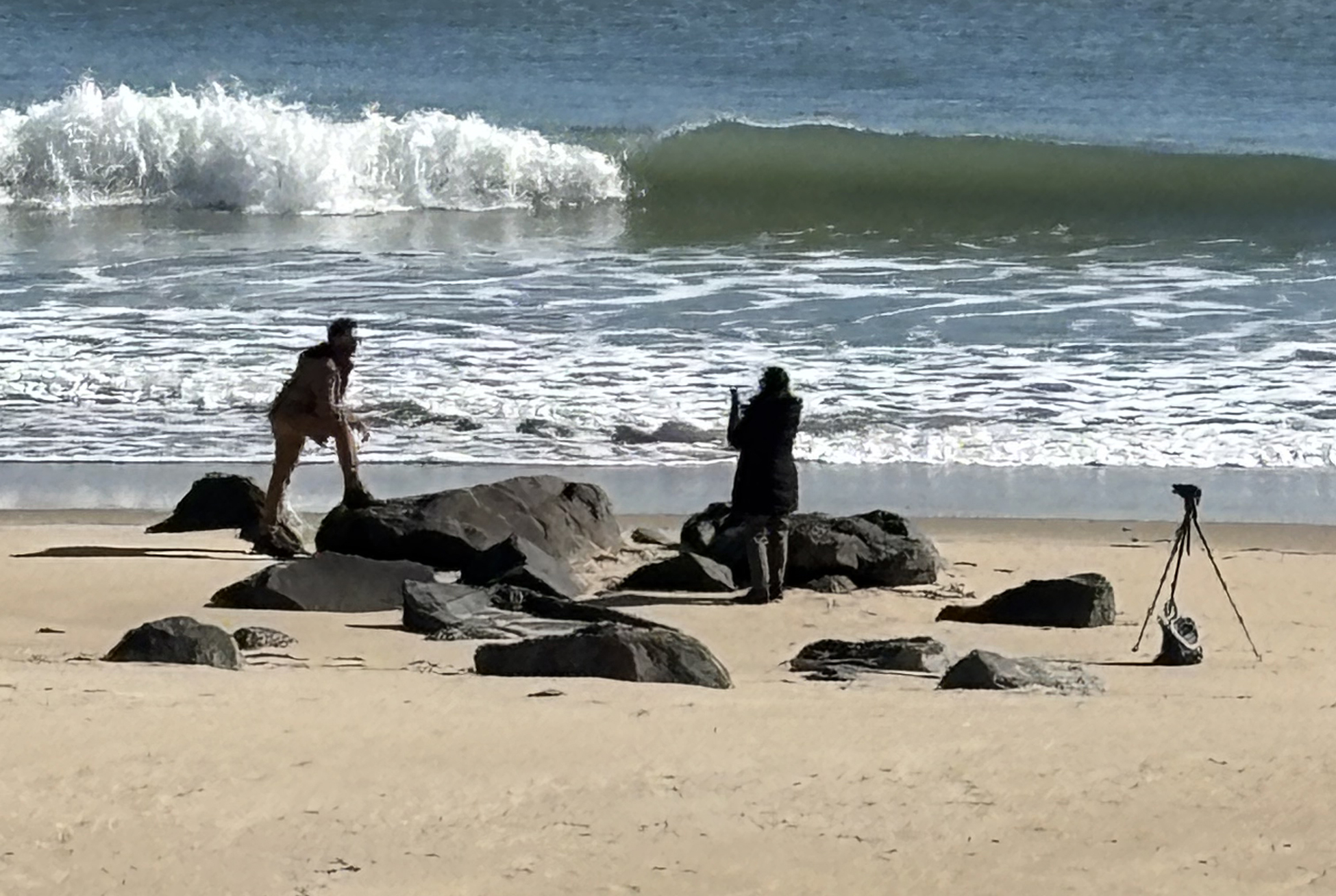 People on a beach beside the ocean, taking pictures, looking for something? Some feelings you can't put into words