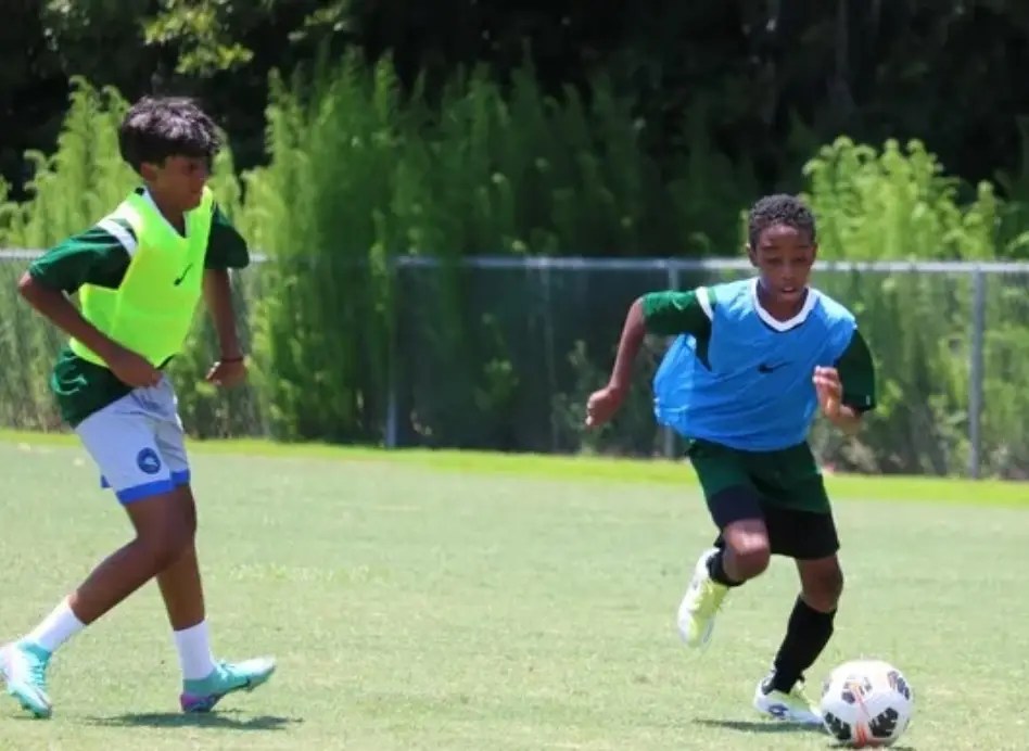 Two youth players competing in a small-sided game in our charleston soccer camp