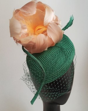 Tocado realizado en buntal verde botella, con flor de plumas  y velo sobre el rostro.Una elección para destacar. Queda perfecto con recogido bajo o a un lado